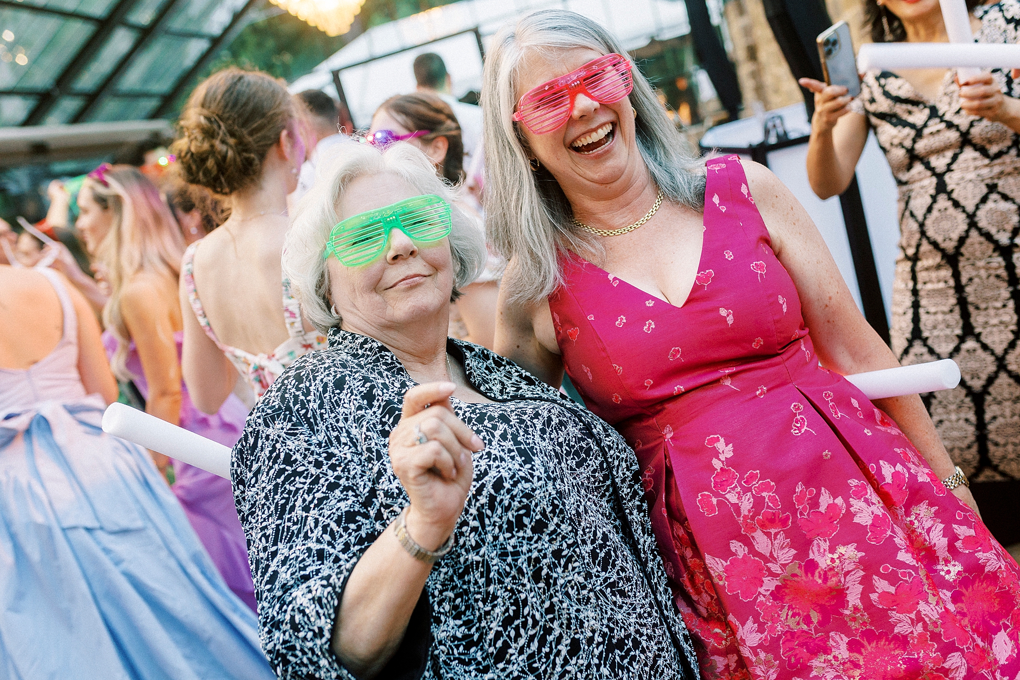 wedding guests dance in neon sunglasses during reception