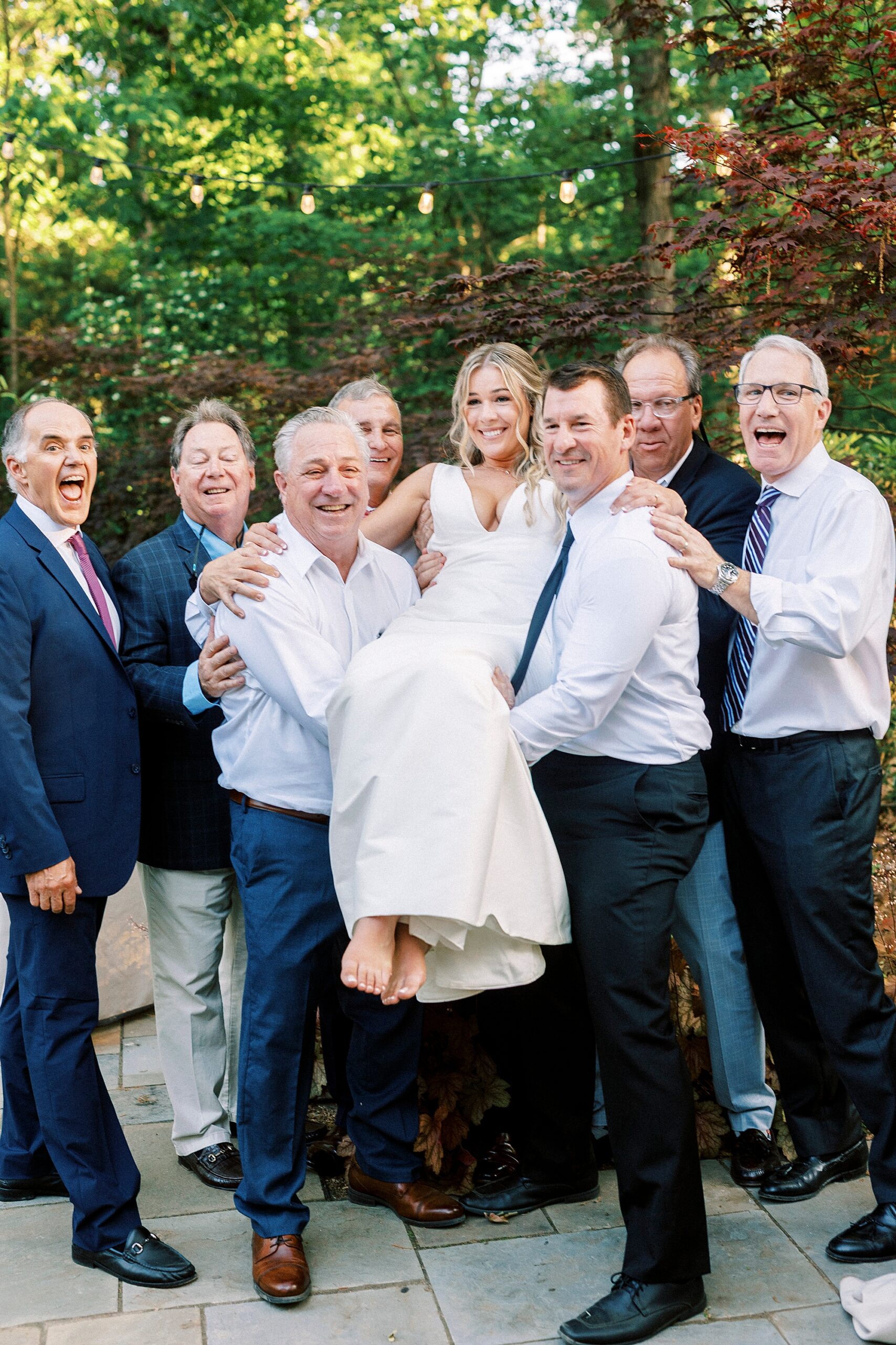 wedding guests lift up bride during cocktail hour