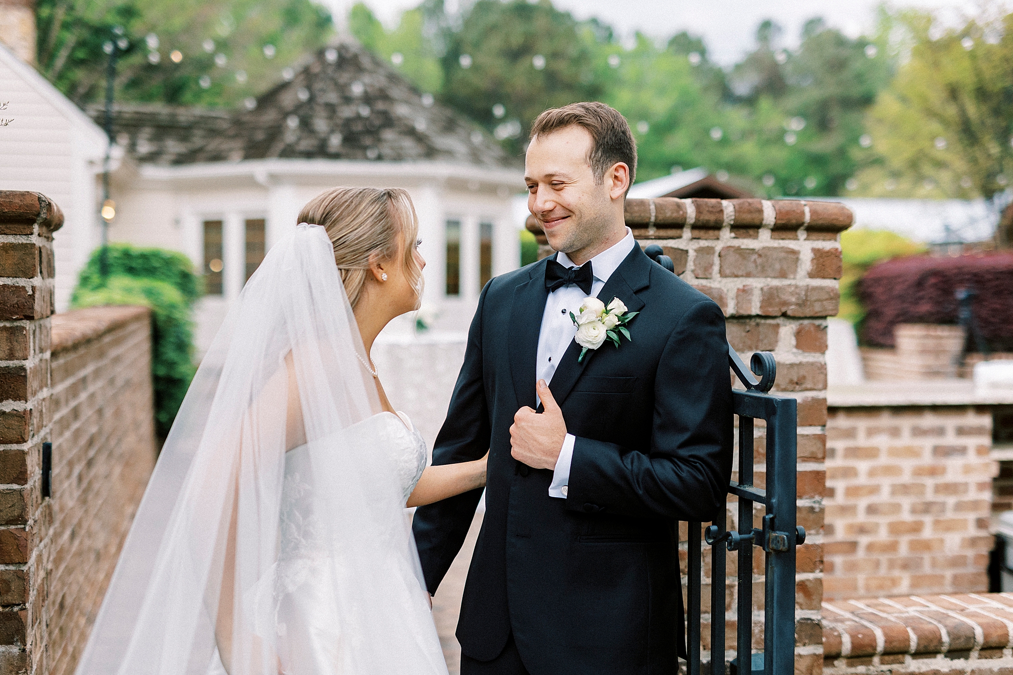 newlyweds laugh near brick gate at the Sutherland