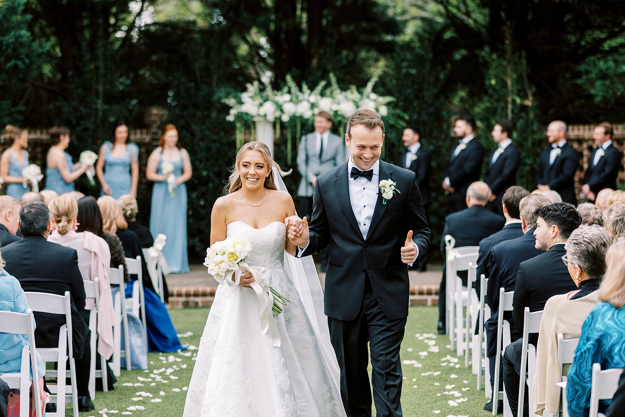 newlyweds wave to guests walking up aisle at the Sutherland