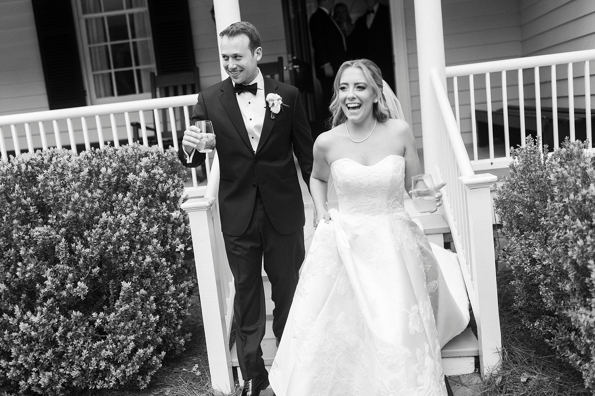 bride and groom laugh holding hands walking down steps in Wake Forest NC