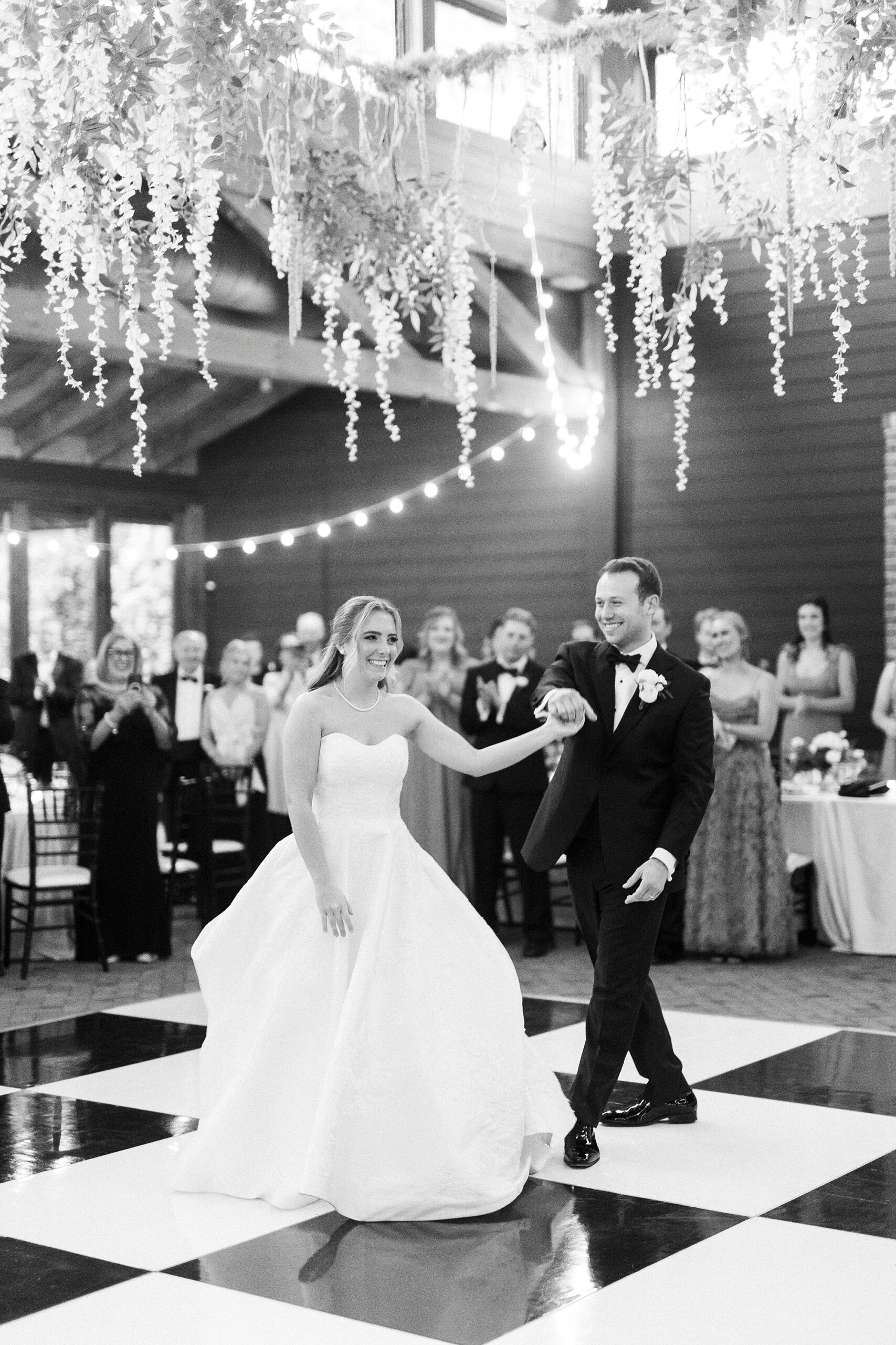 groom twirls bride on dance floor inside the Sutherland Pavilion 