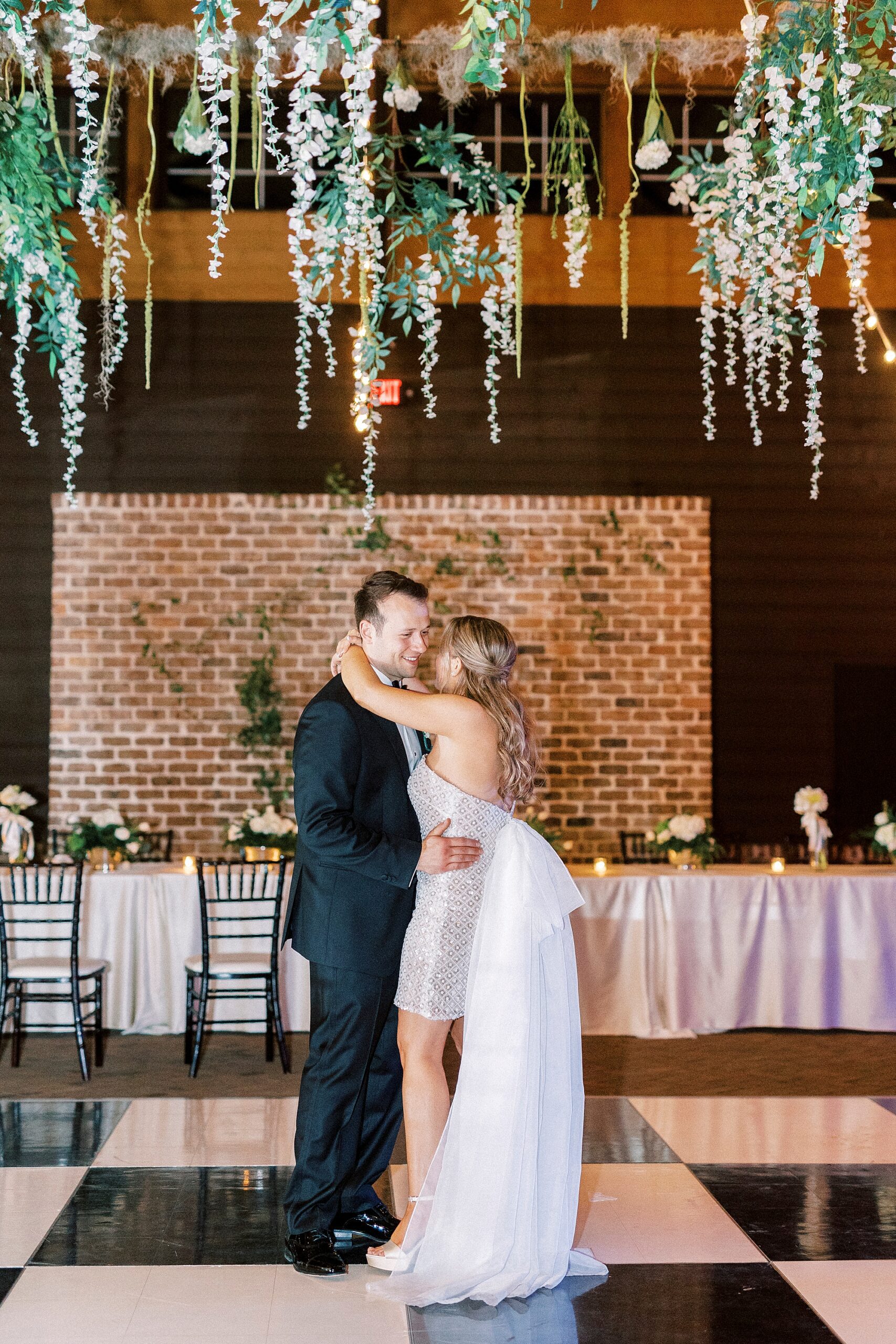 bride and groom dance together on black and white floor during Wake Forest NC wedding reception in pavilion