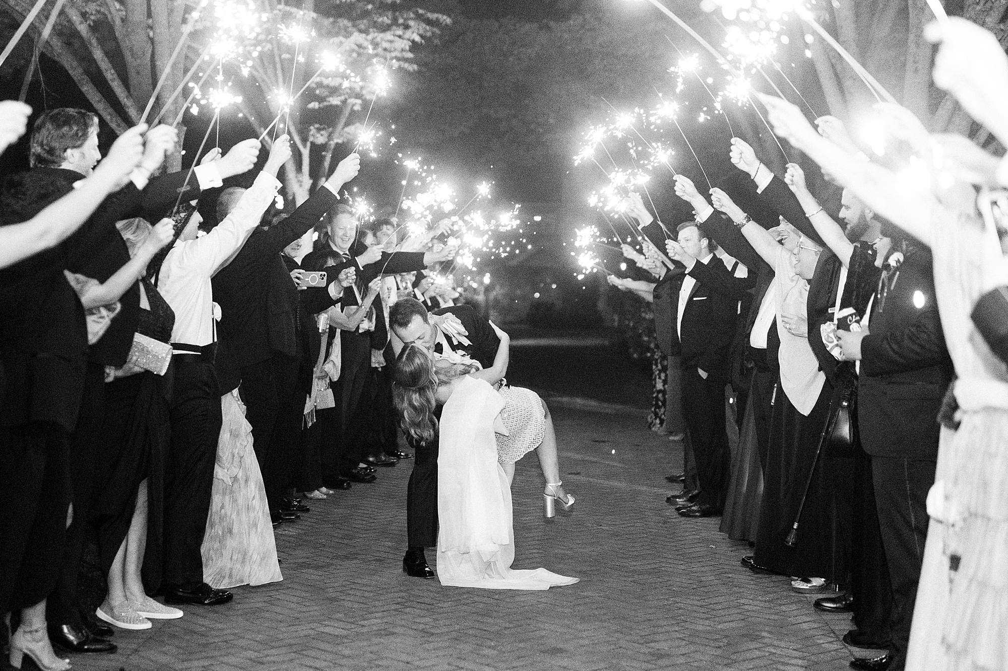 newlyweds kiss during sparkler exit from NC wedding reception