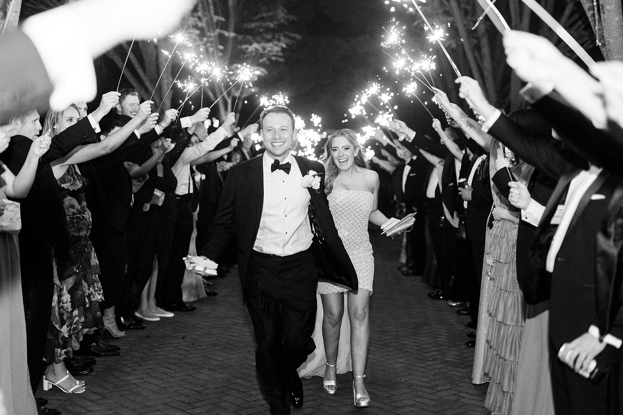 bride and groom laugh walking through sparkler exit