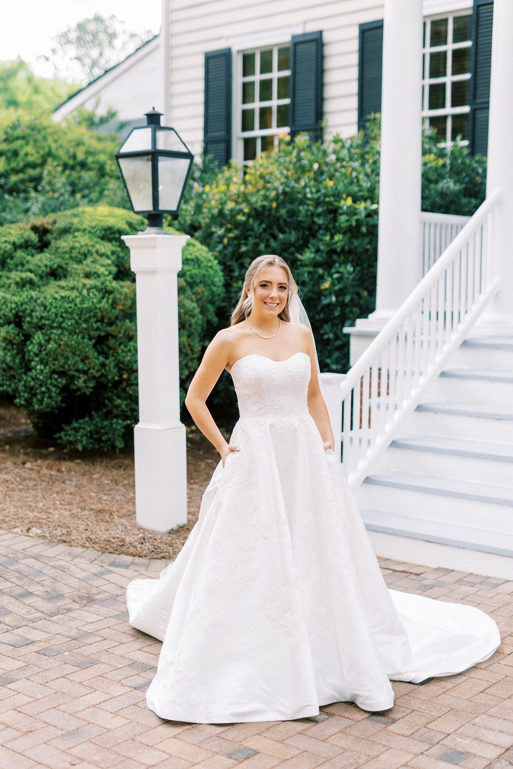bride poses with hand on hip outside staircase of the Sutherland