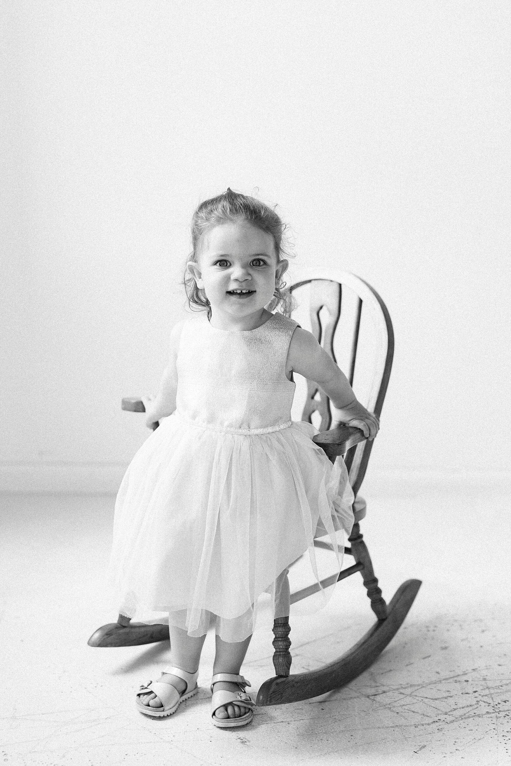 black and white photo of two year old in rocking chair