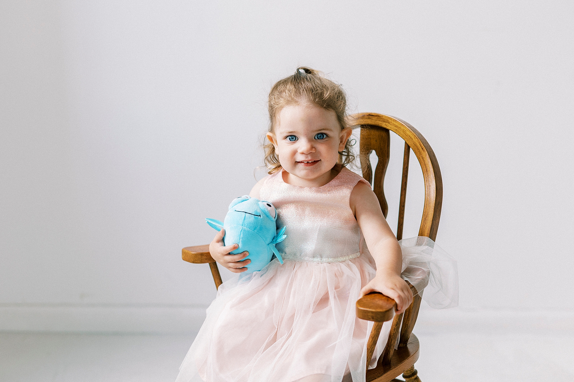girl holds blue stuffed animal during Birthday Photos at Charlotte NC Photography Studio
