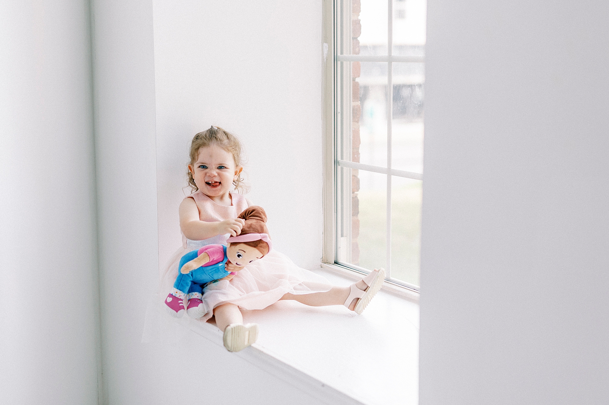 toddler sits in window of Charlotte photography studio 