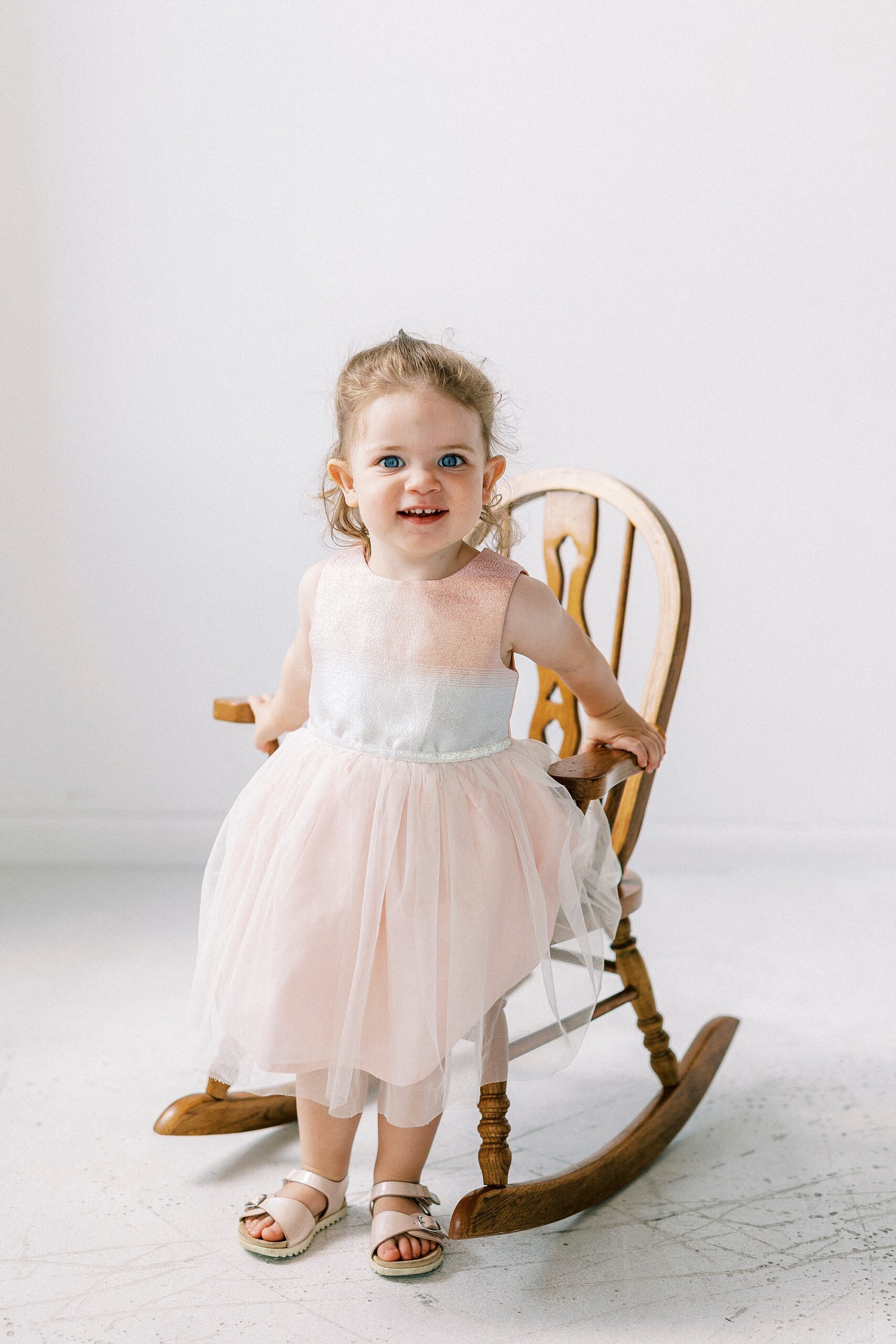 girl sits in rocking chair during Birthday Photos at Charlotte NC Photography Studio