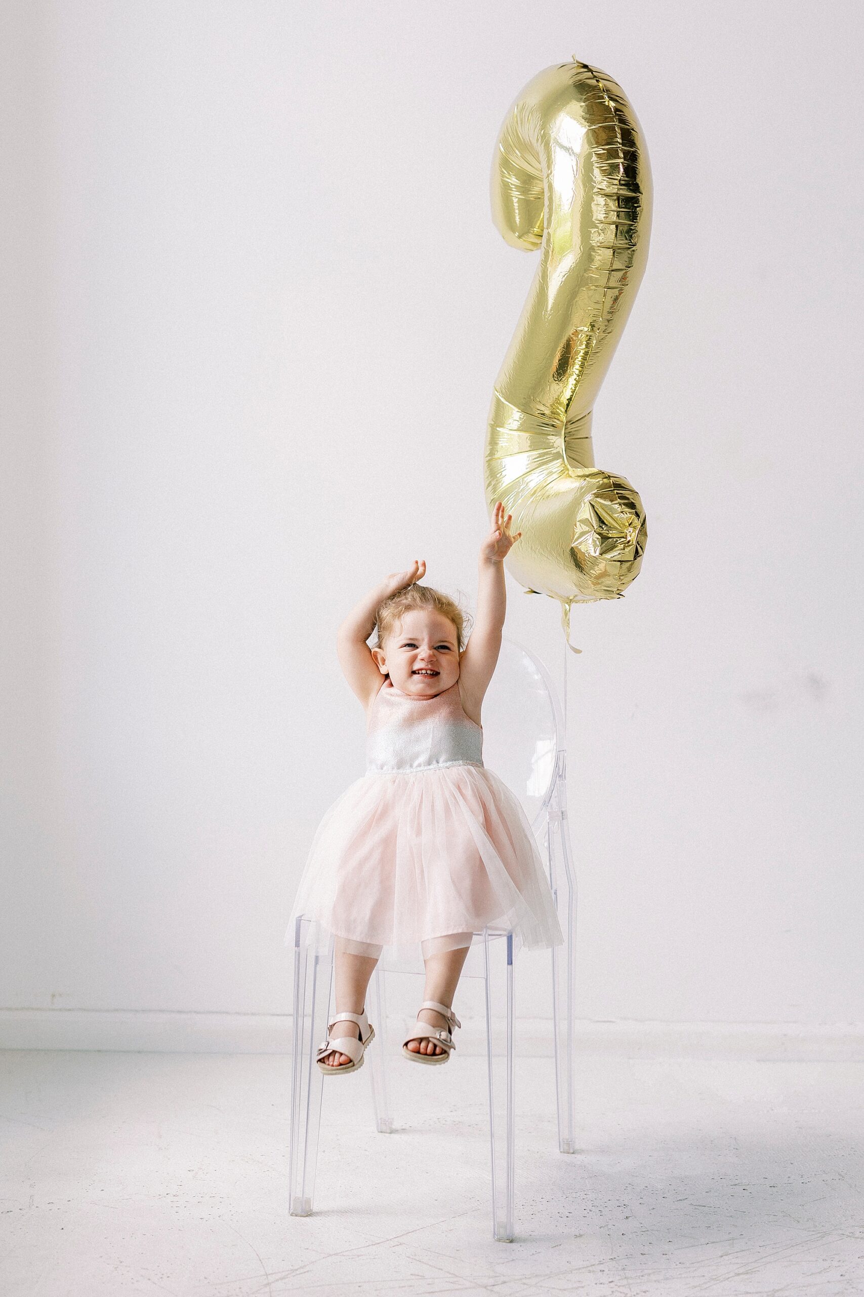 girl plays with gold 2 balloon in studio 