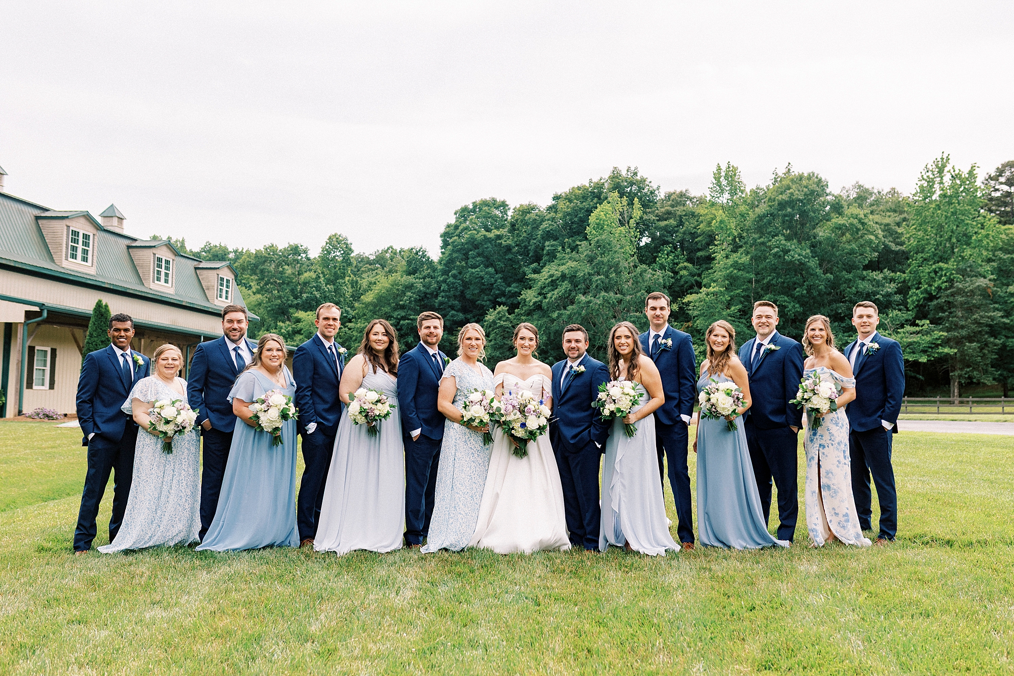 bride and groom stand in line with wedding party