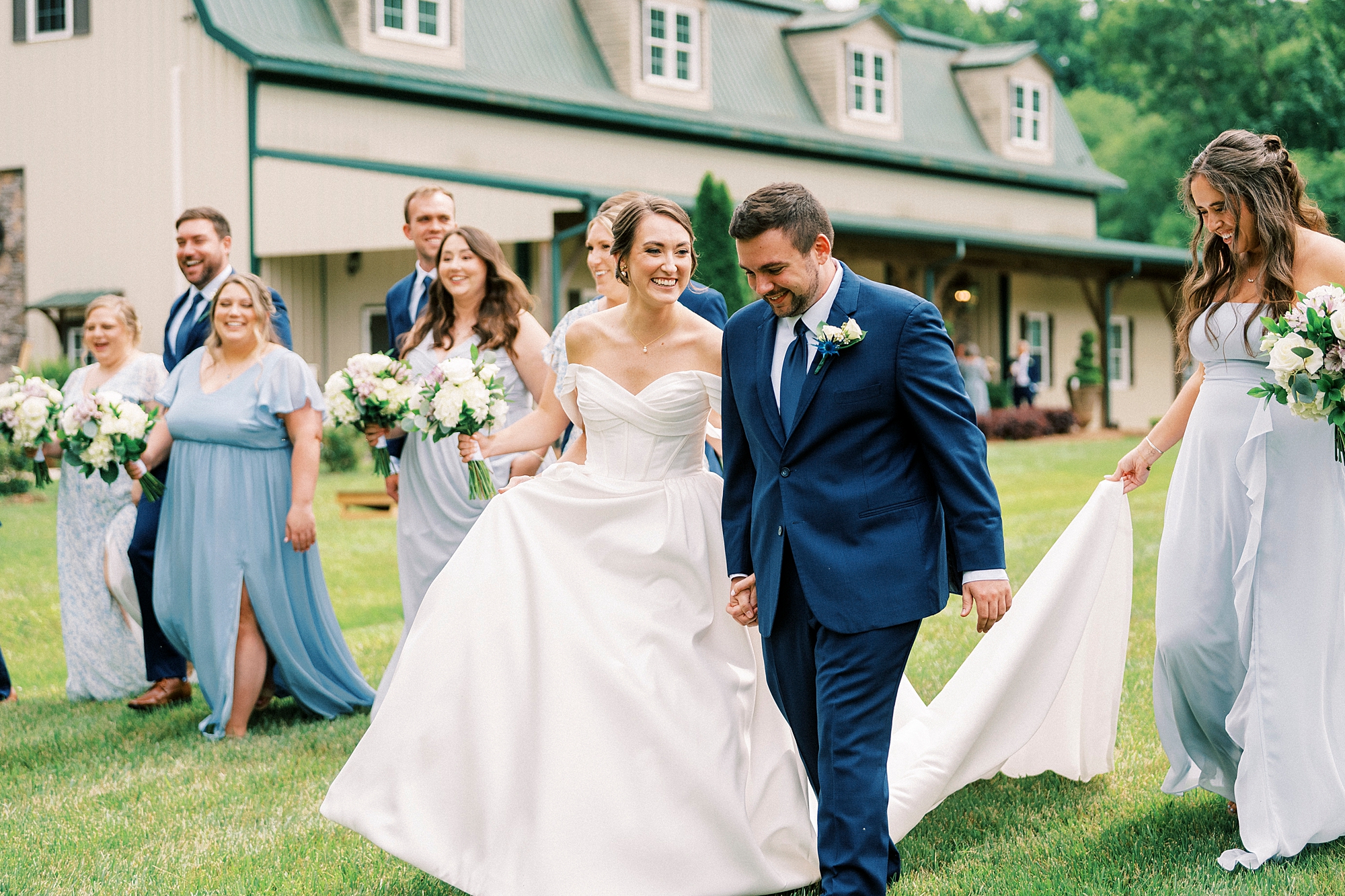 bride and groom walk with wedding party on lawn at Low Meadows Estate