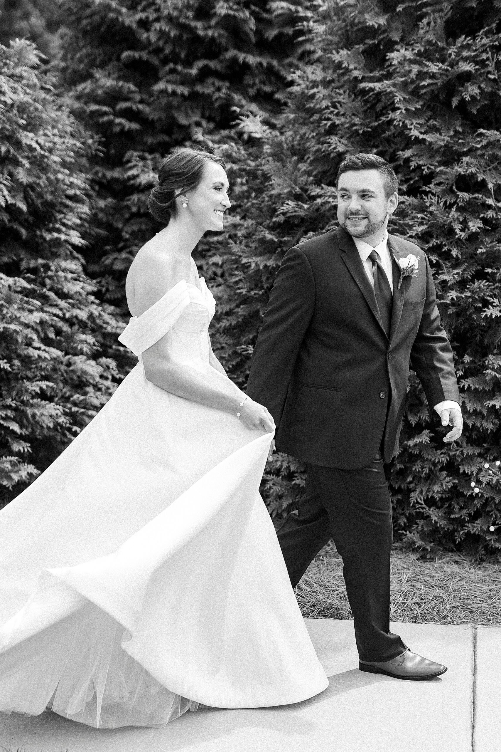 bride and groom hold hands walking through Low Meadows Estate