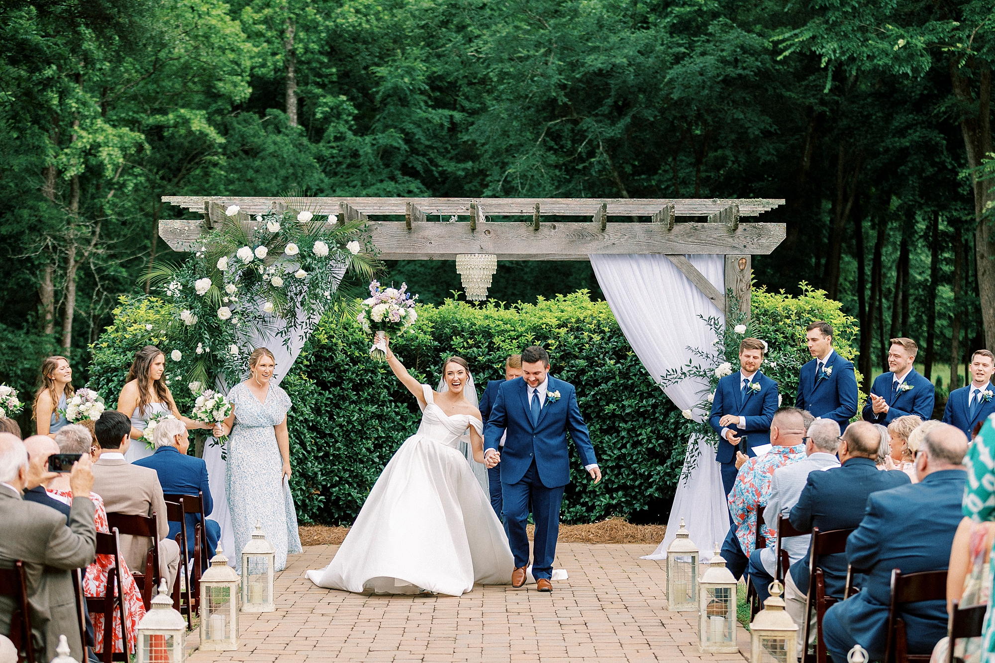 newlyweds cheer turning to face guests during wedding ceremony 