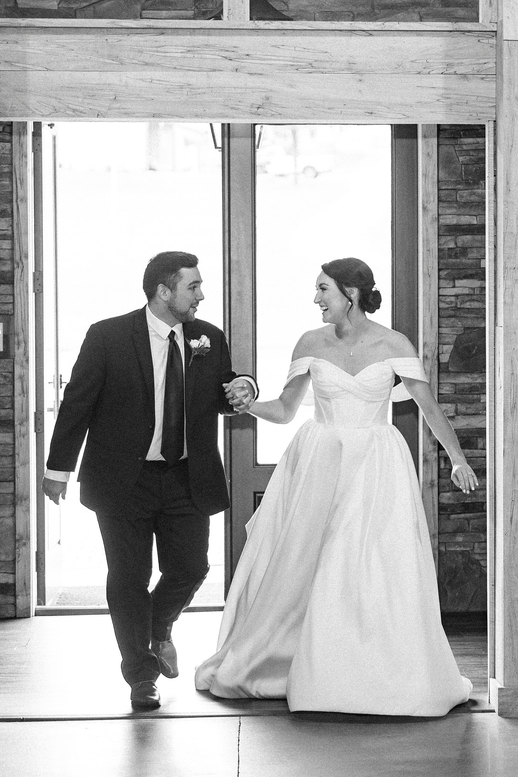 bride and groom hold hands entering reception at Low Meadows Estate