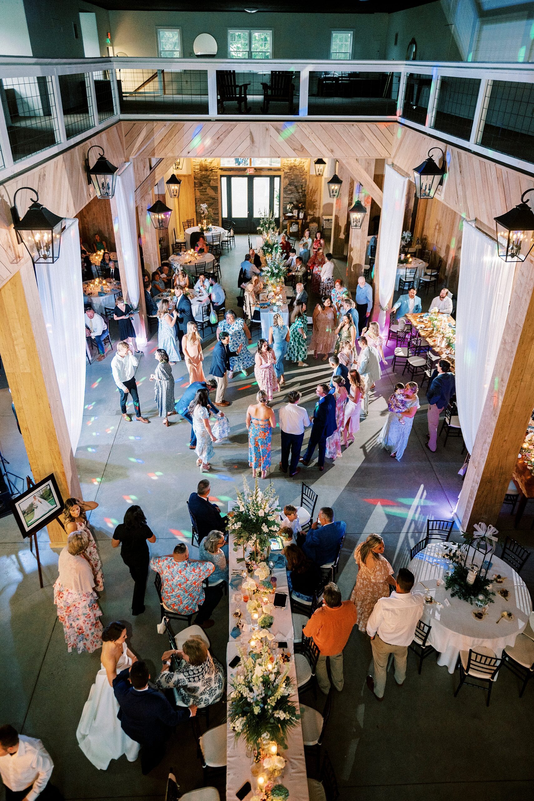 wedding guests mingle during reception in bottom level of barn at Low Meadows Estate