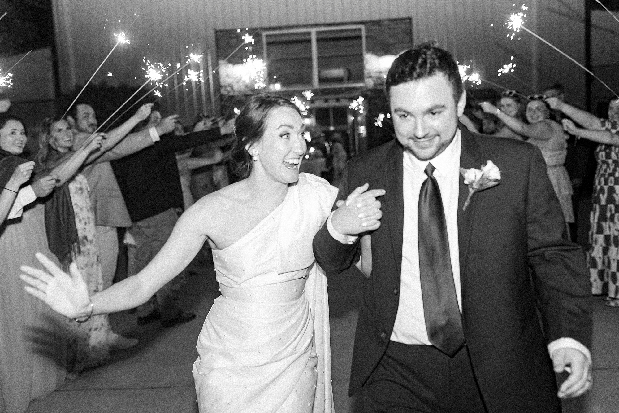 bride and groom laugh together through sparkler exit at Low Meadows Estate
