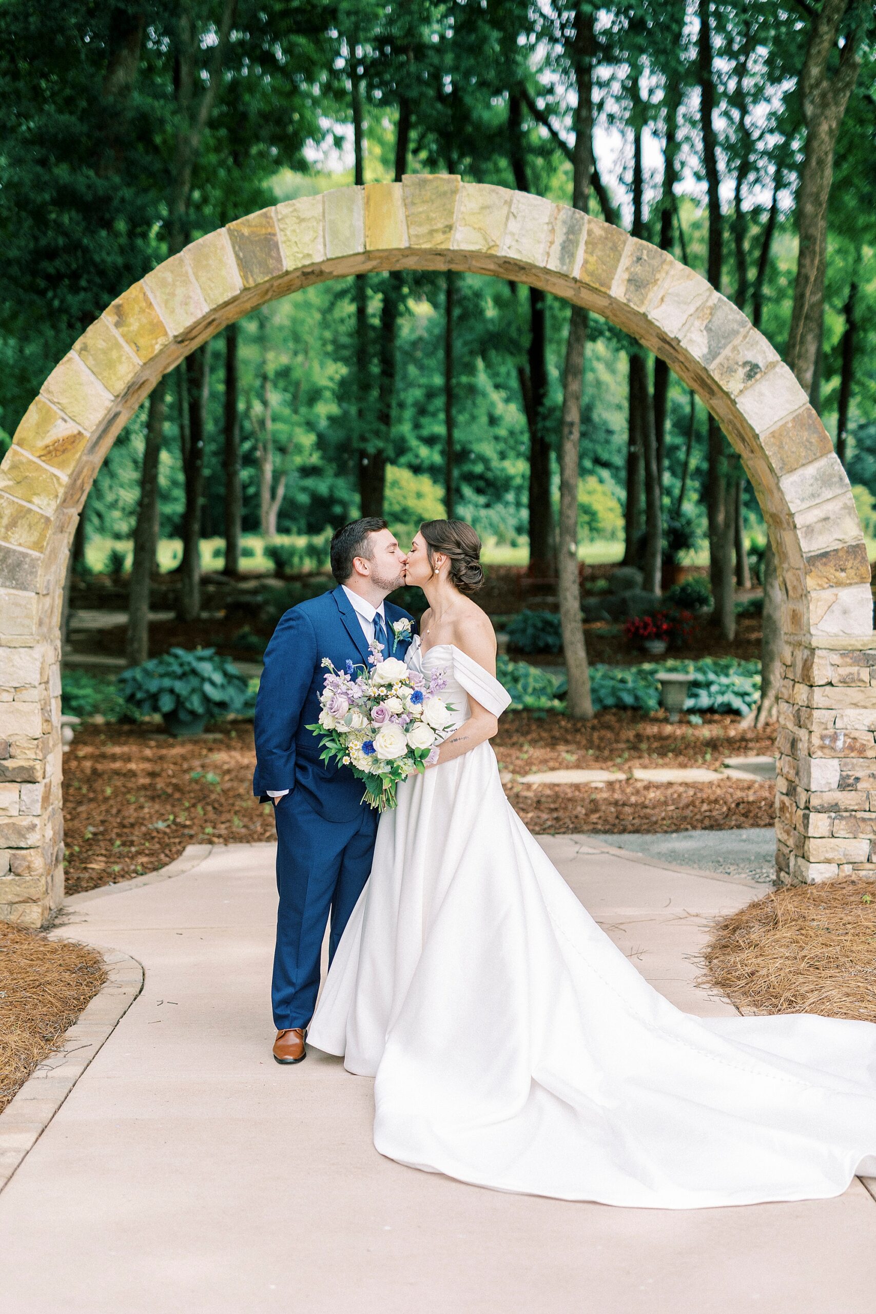 bride and groom kiss under stone arch at Low Meadows Estate
