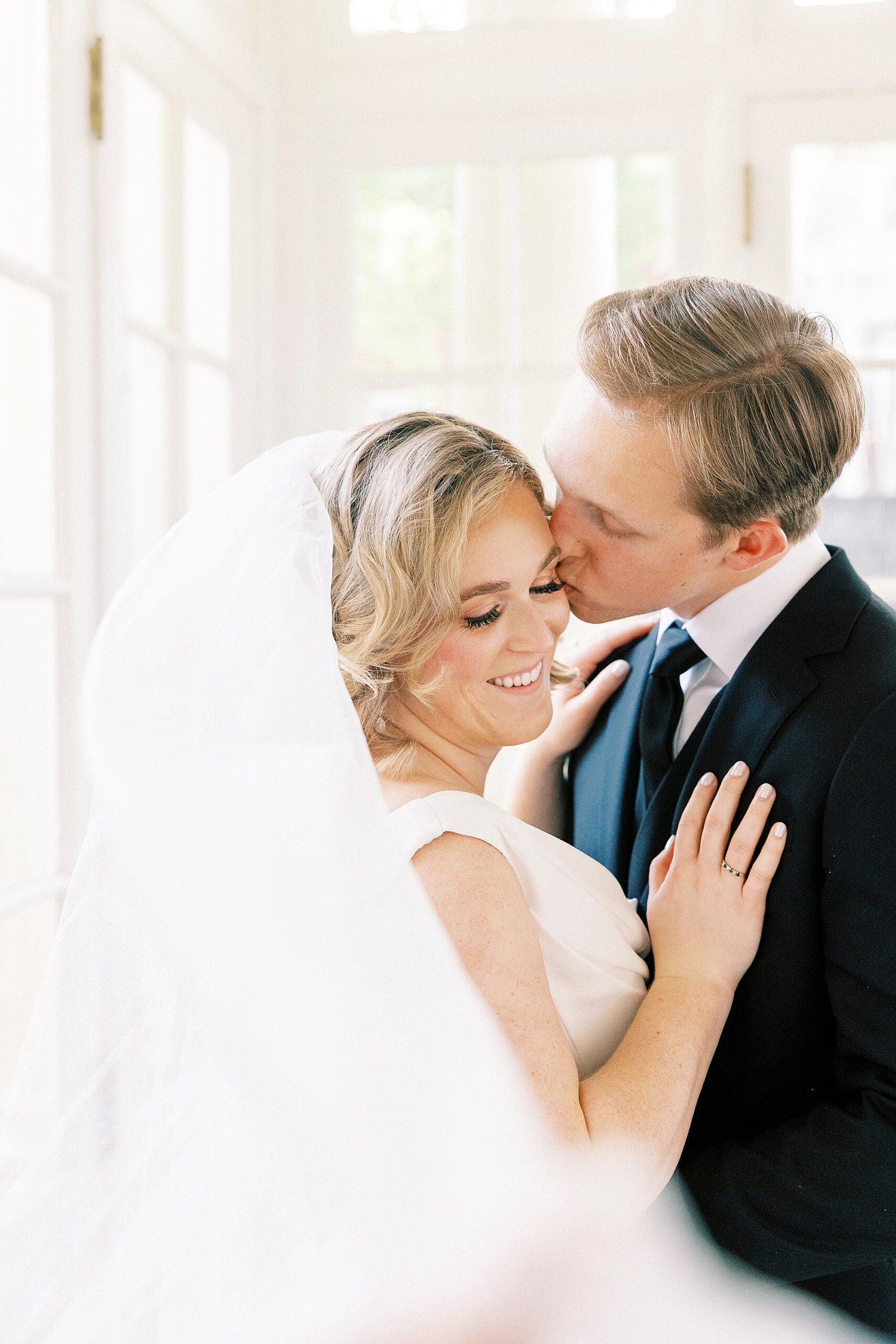 groom kisses bride's cheek during portraits at Separk Mansion