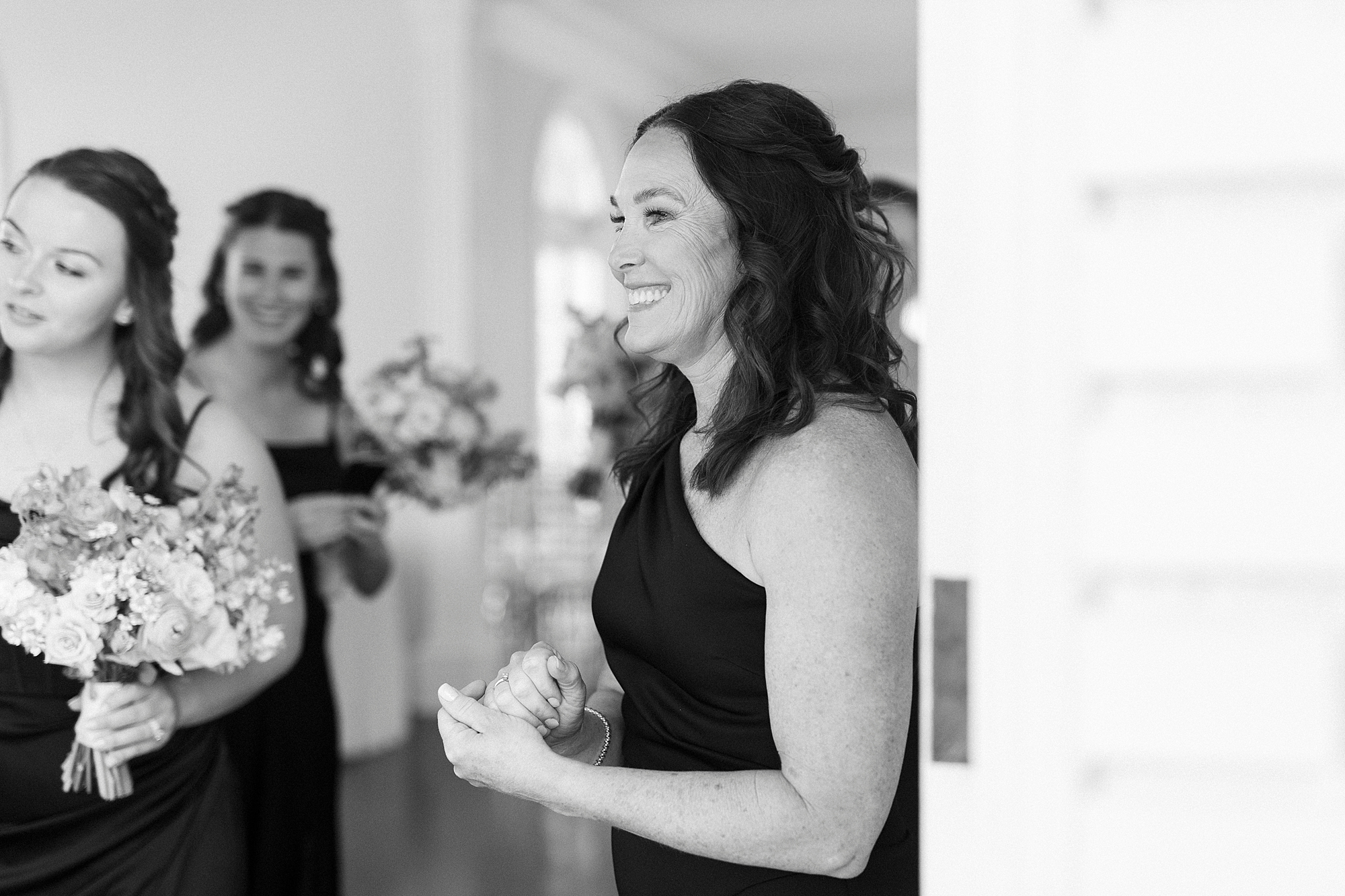 bridesmaids smile during bride's first look with dad