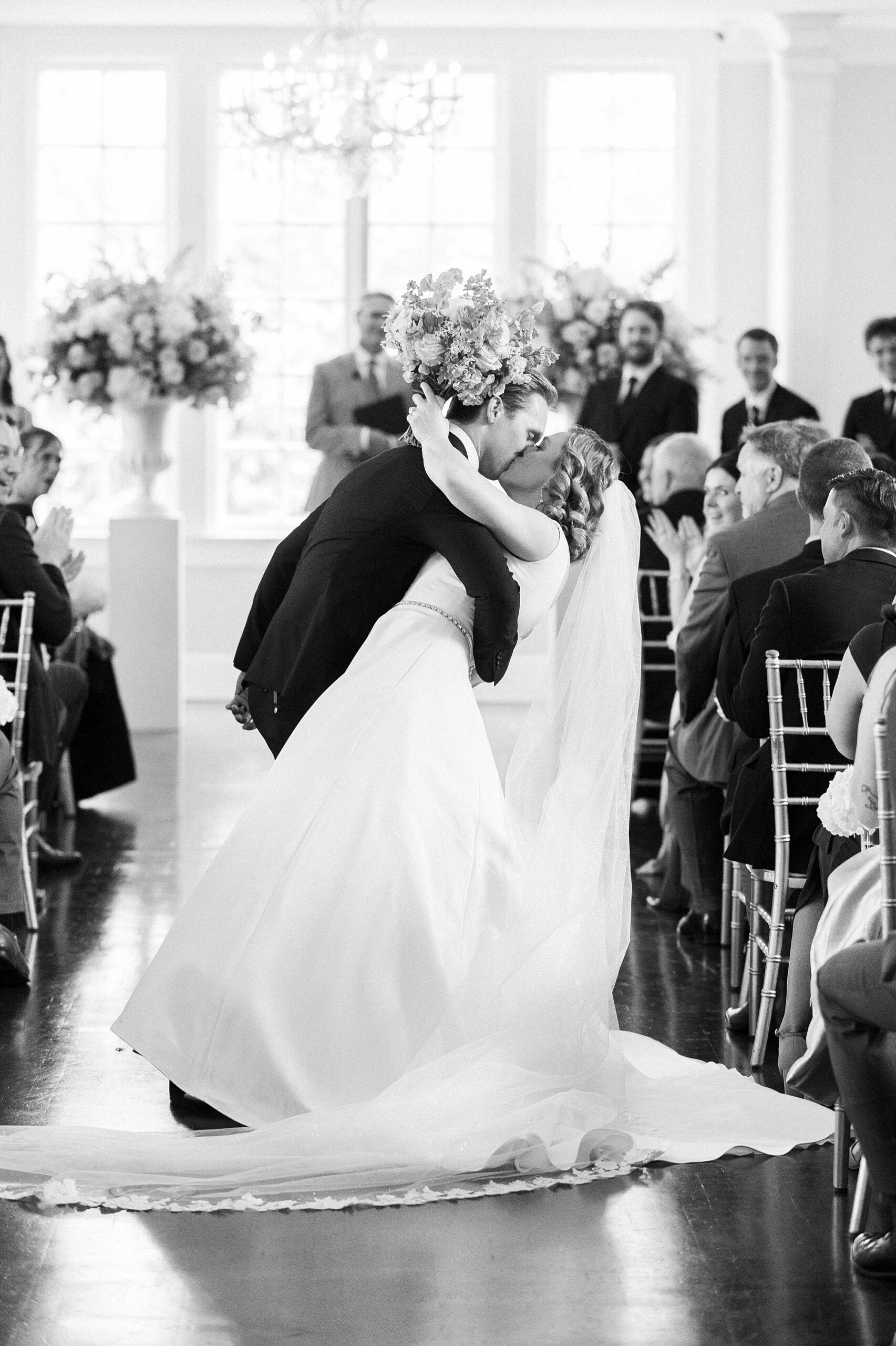 groom dips bride kissing her in aisle during wedding ceremony at Separk Mansion