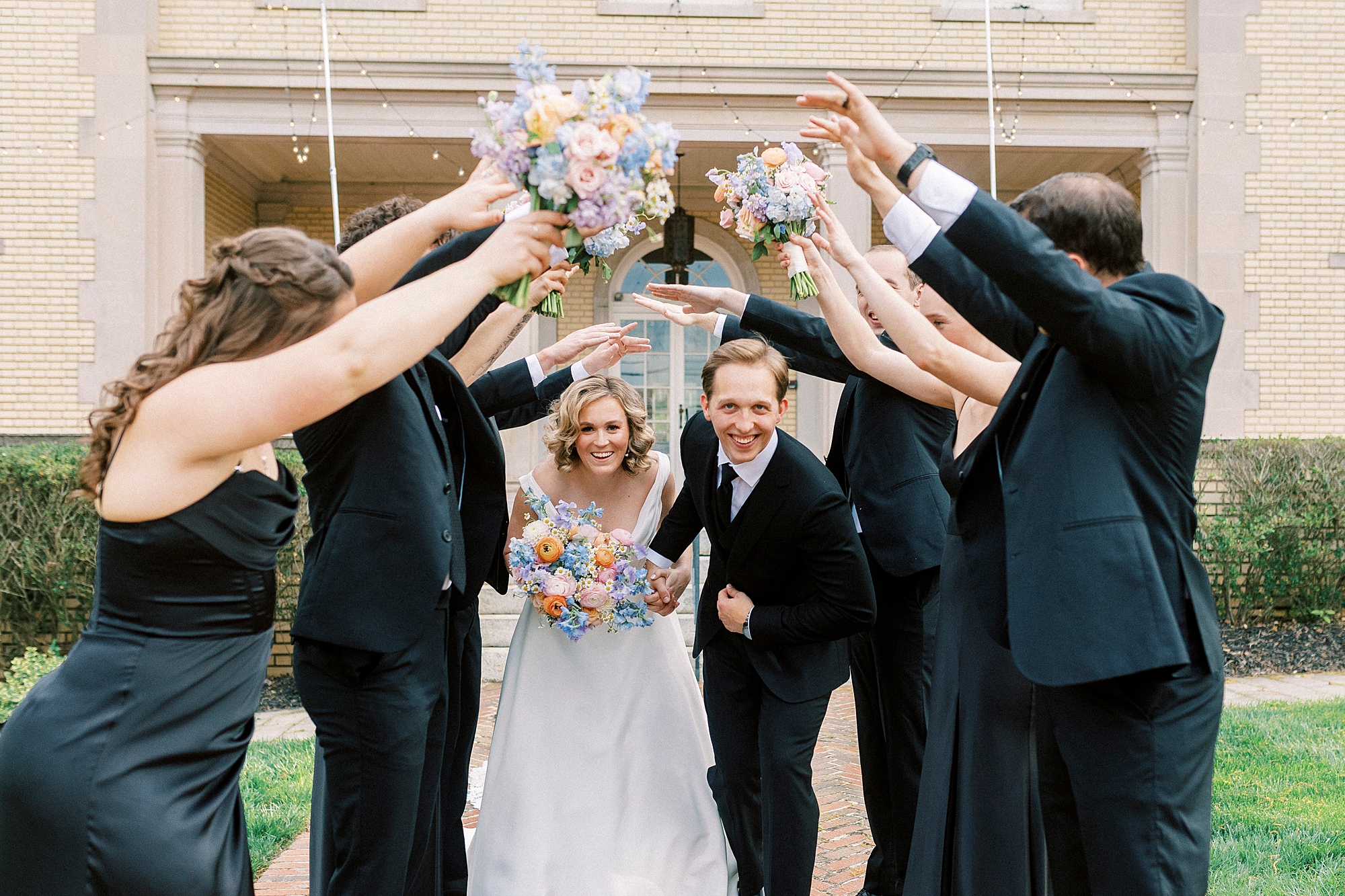 bride and groom walk through tunnel created by bridal party