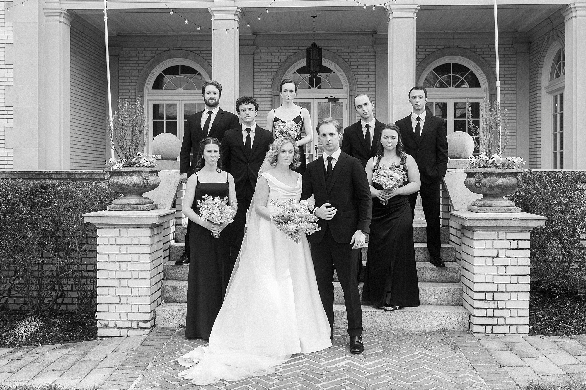 bride and groom stand with wedding party on steps of Separk Mansion