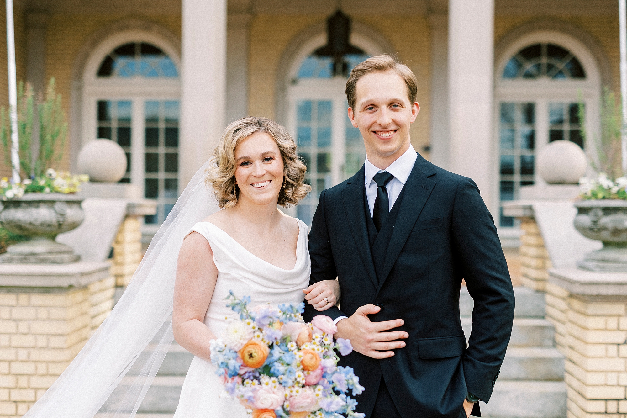 bride and groom stand together in front of Separk Mansion