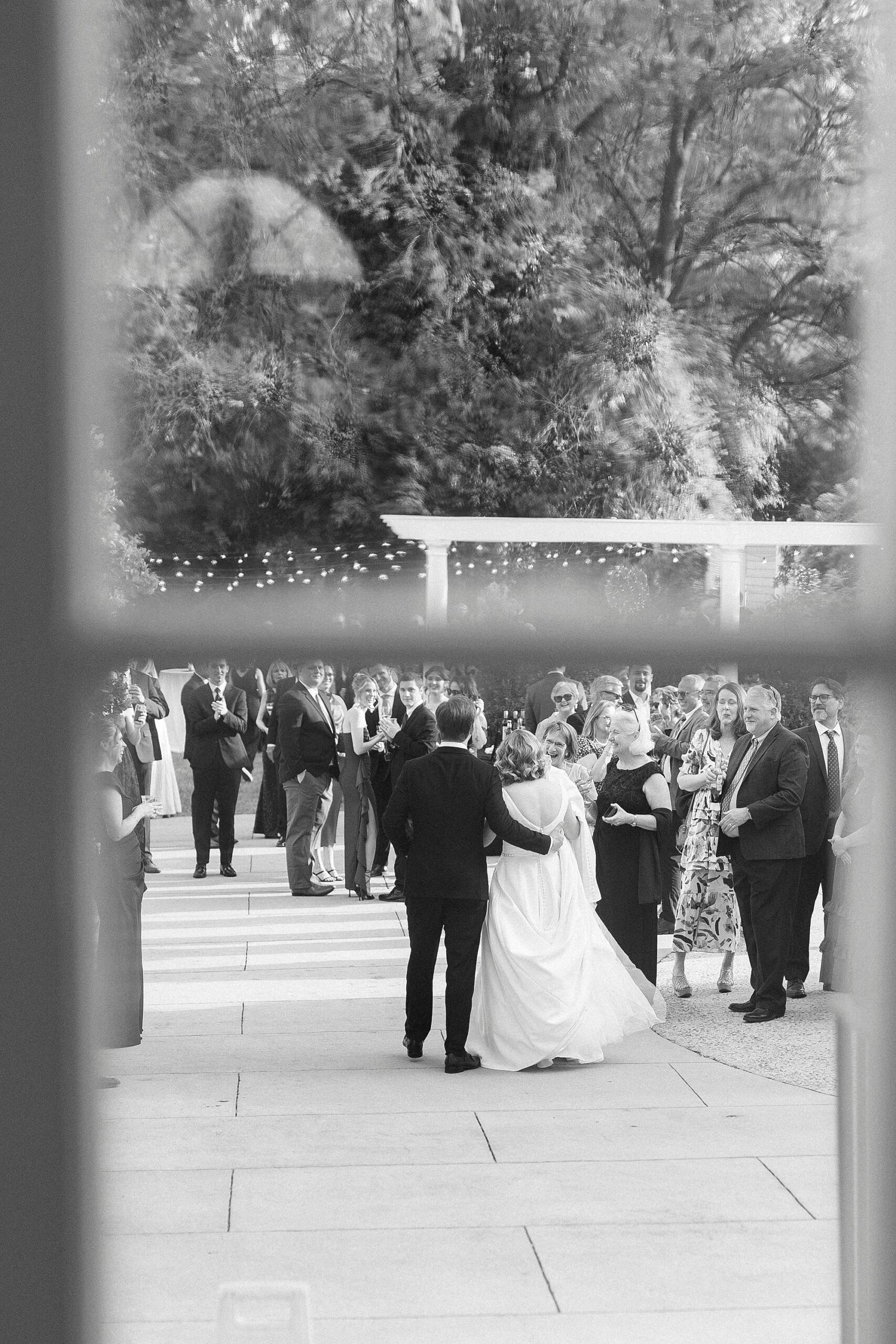 photograph of wedding party on lawn through window of Separk Mansion