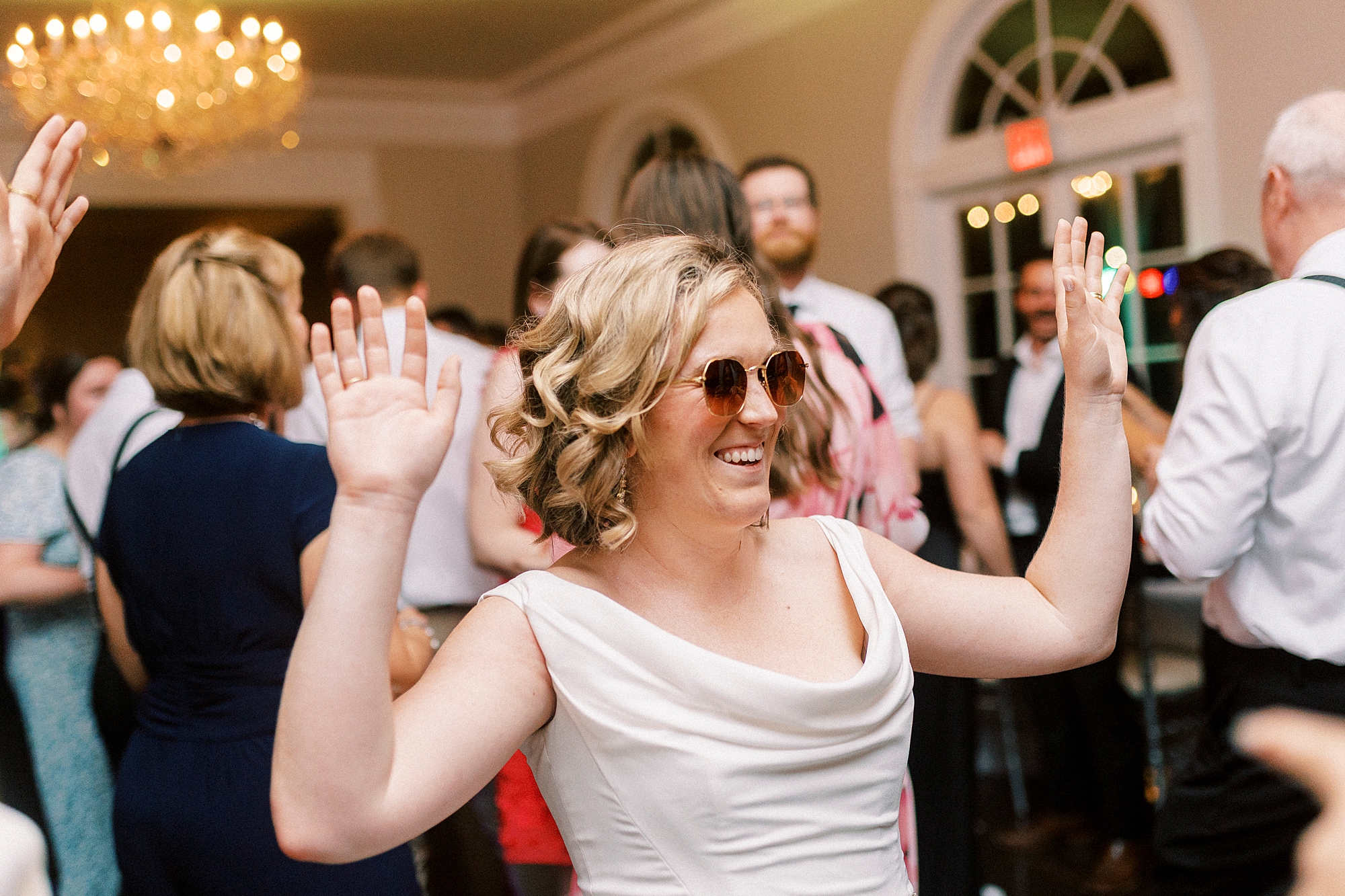 bride smiles on dance floor wearing sunglasses