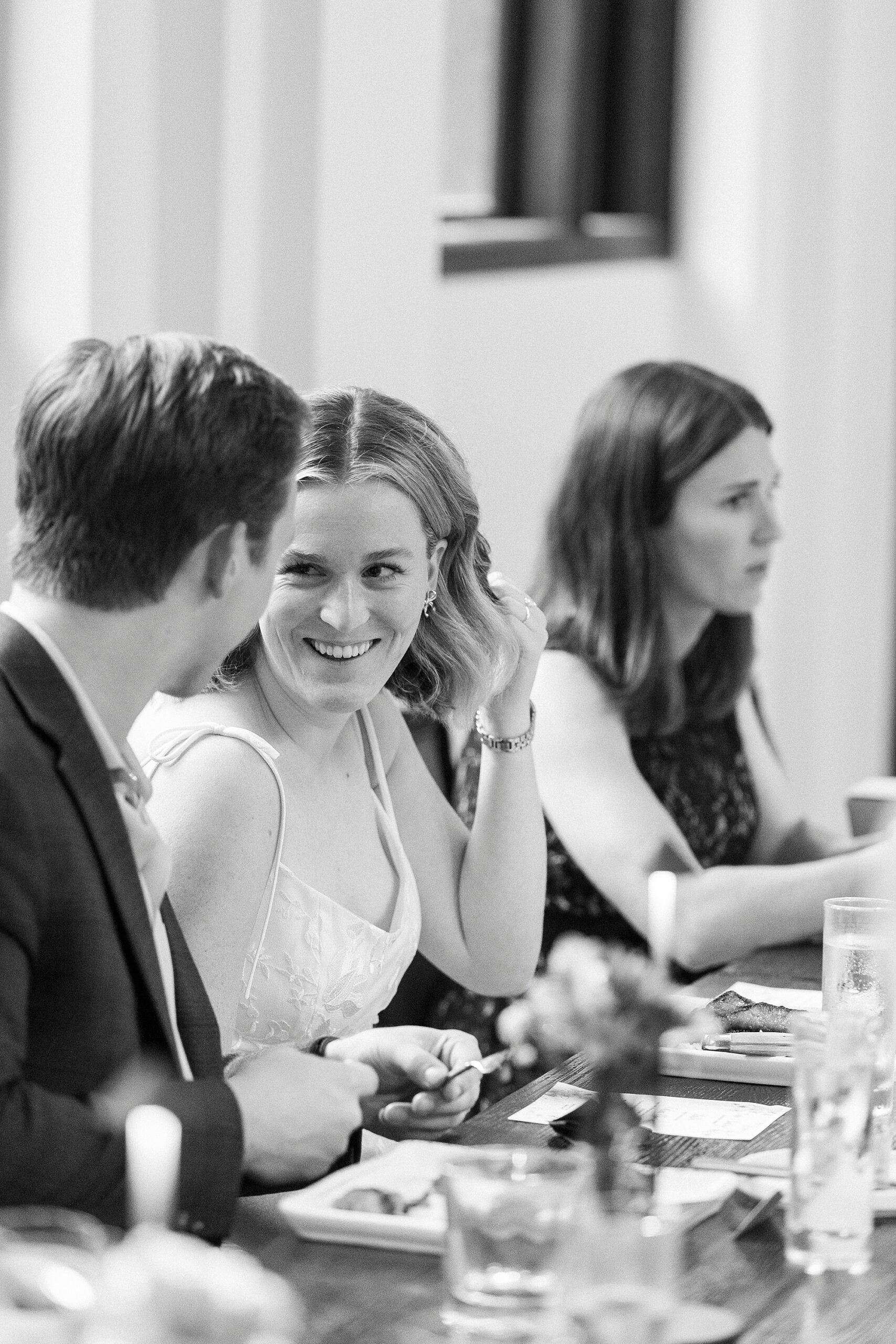 bride looks over at groom during reception dinner 