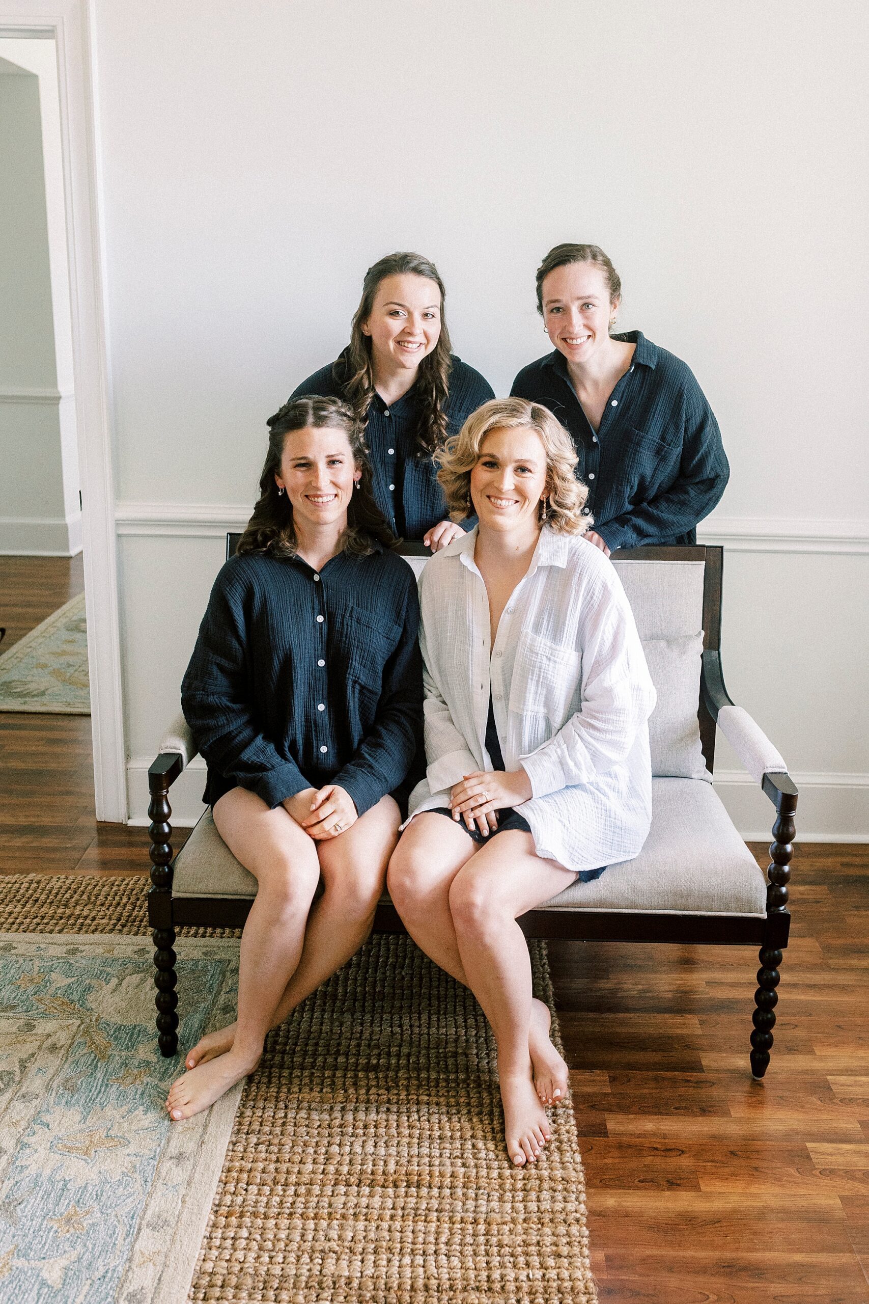 bride sits with bridesmaids in black pajamas 