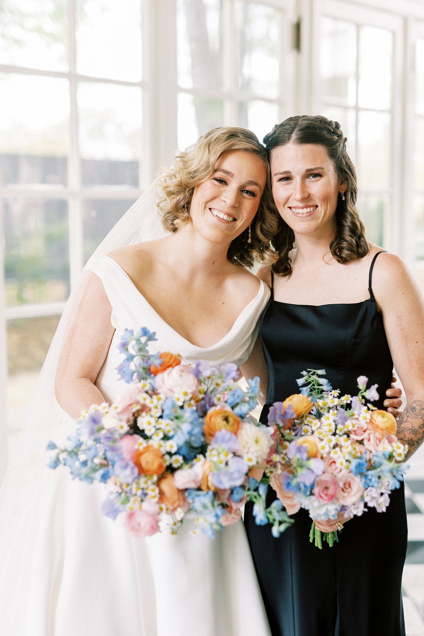 bride leans head against bridesmaid's shoulder