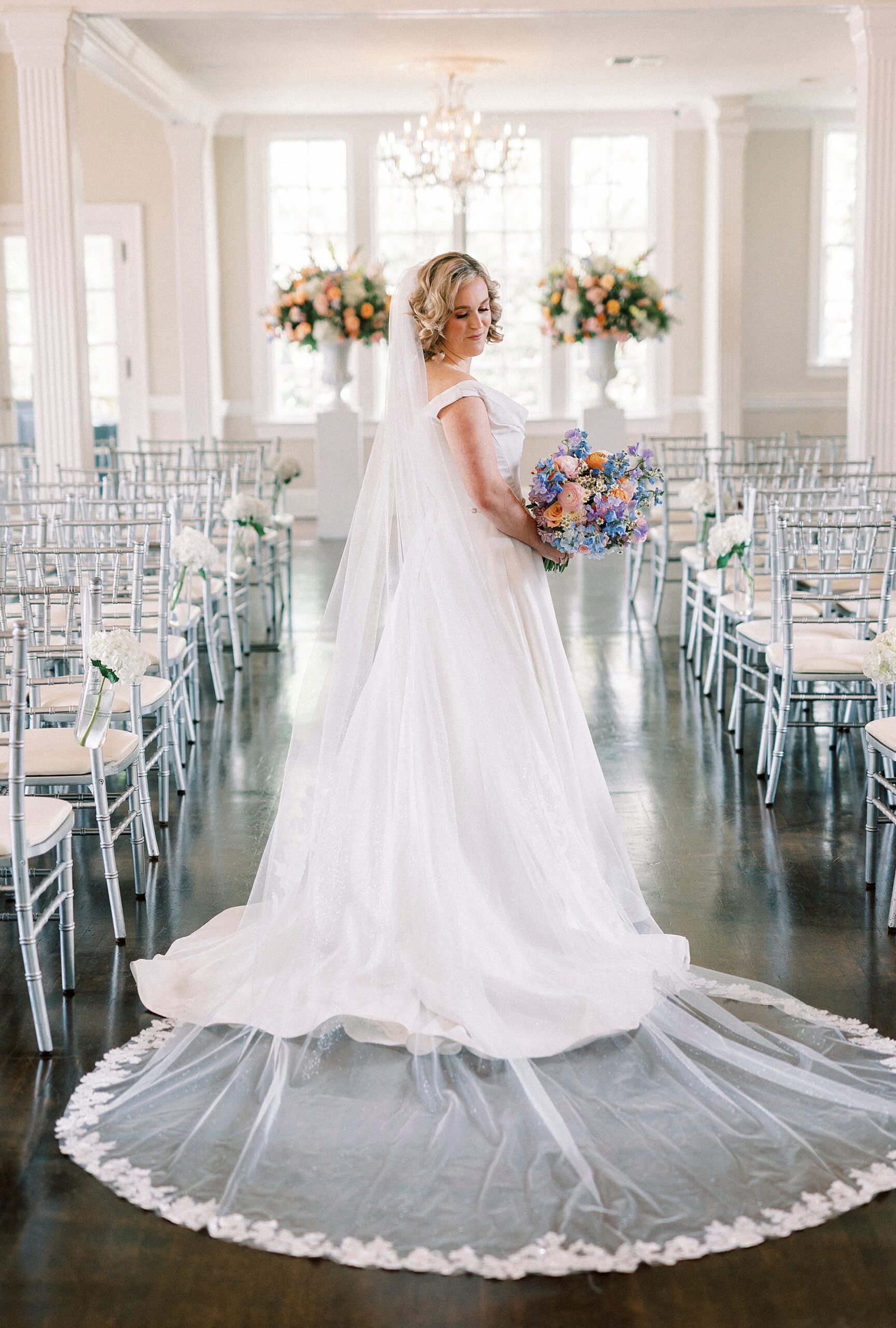 bride looks over shoulder in aisle of Separk Mansion