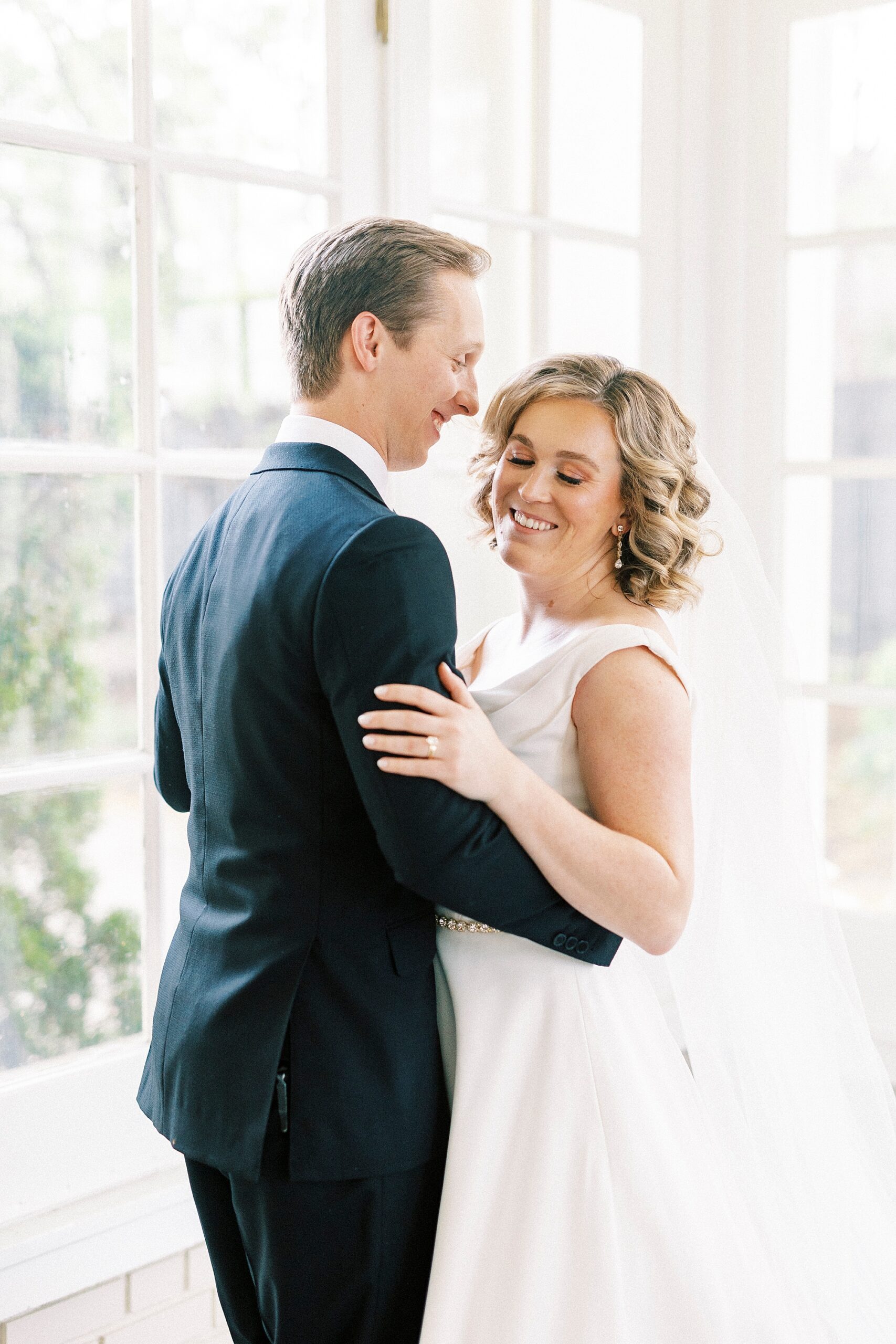 bride and groom hug inside sunroom of Separk Mansion