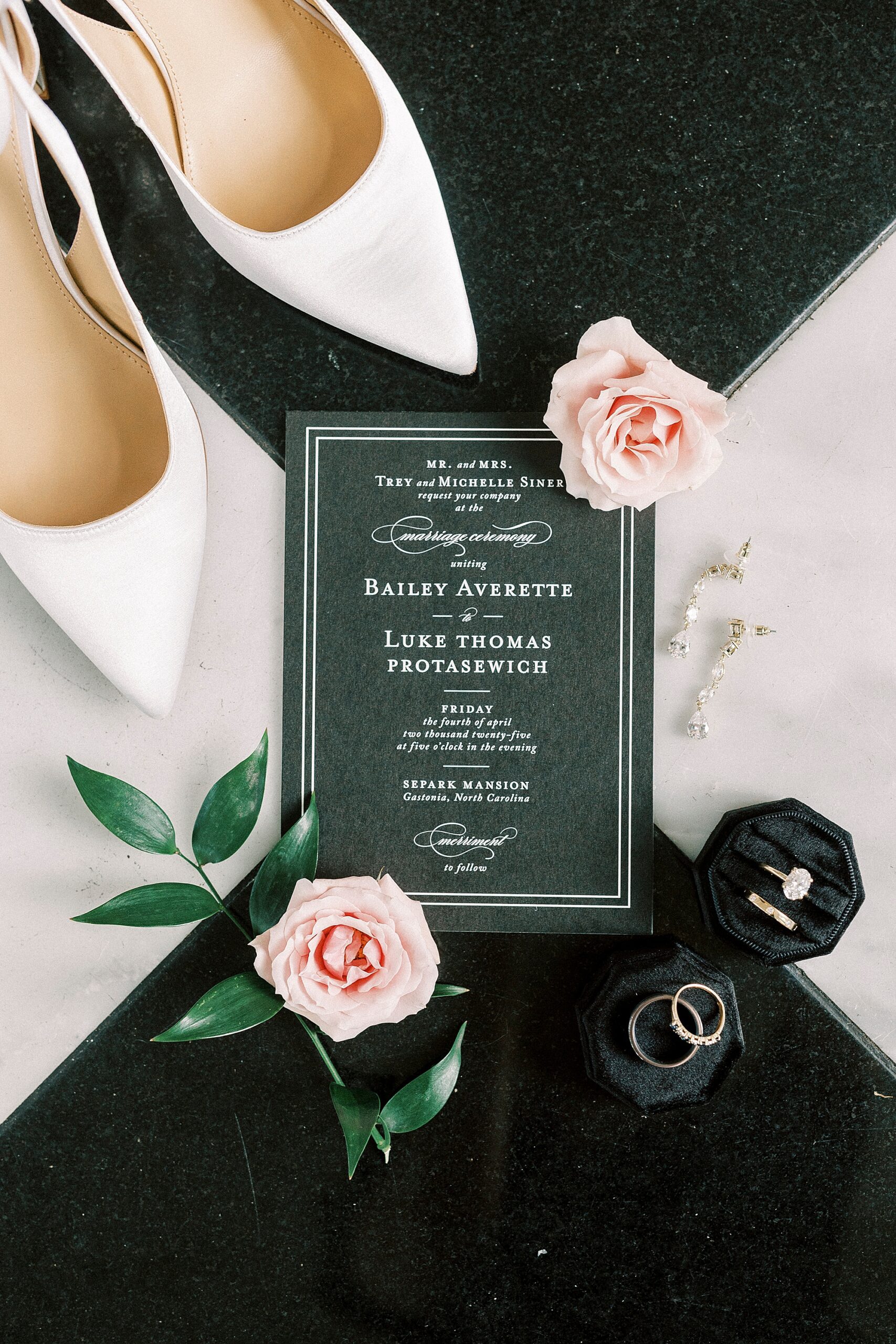 white shoes and pink roses around black and white invitation suite 
