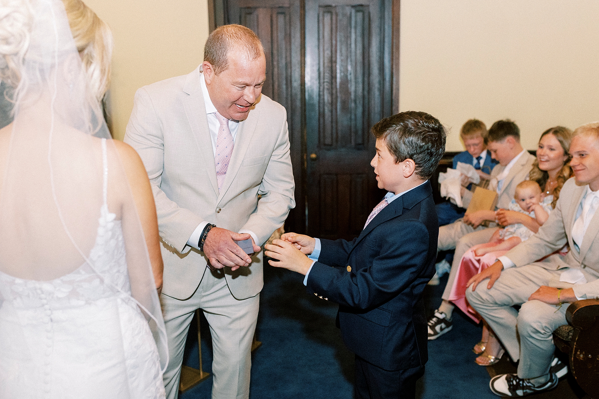 son hands father rings during wedding ceremony at St. Mary's Chapel