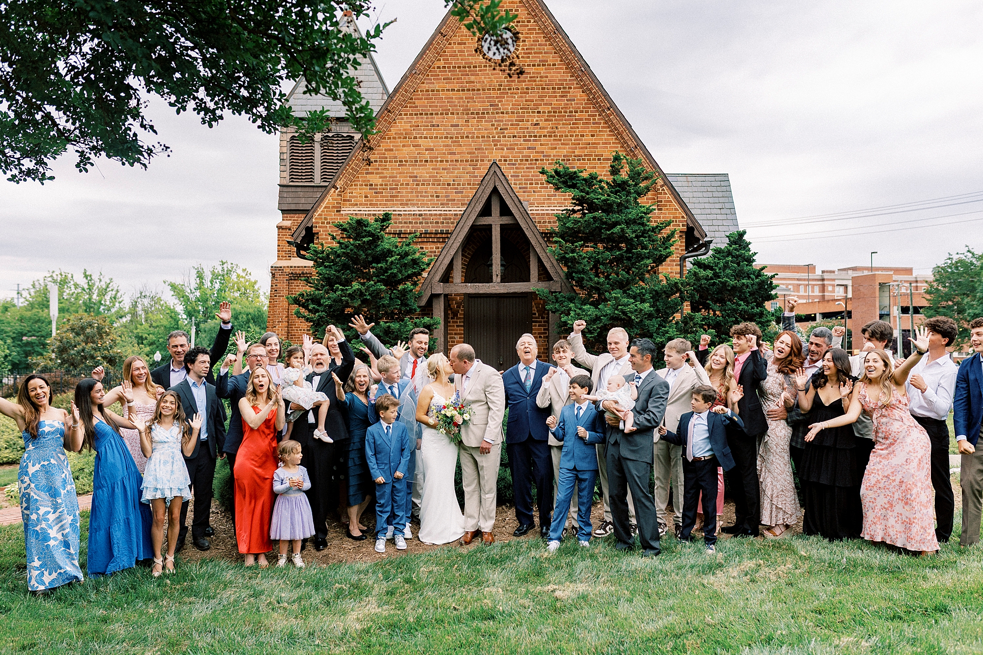 newlyweds kiss outside St. Mary's Chapel while guests cheer 