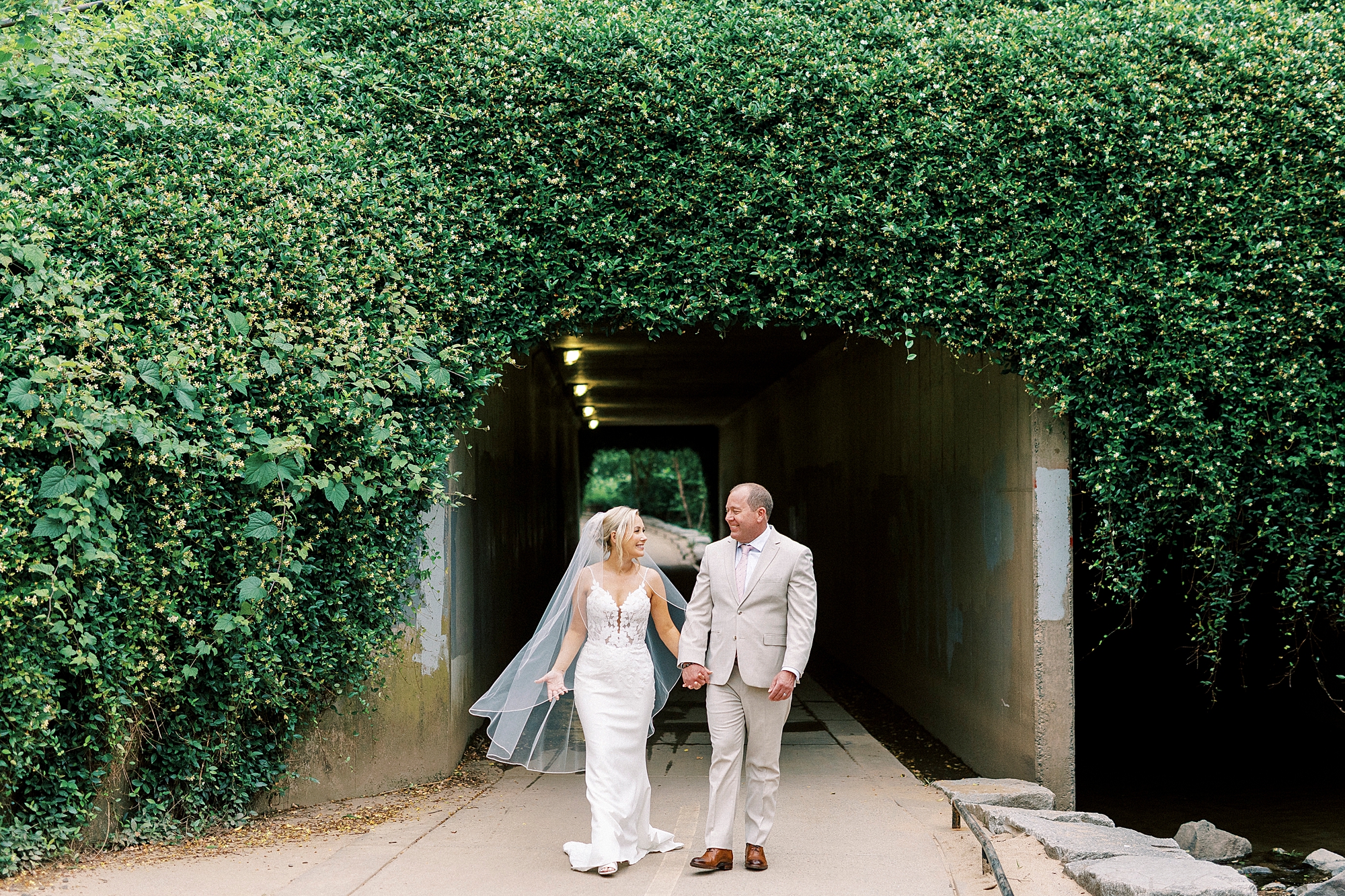  bride and groom walk through tunnel in Charlotte NC park
