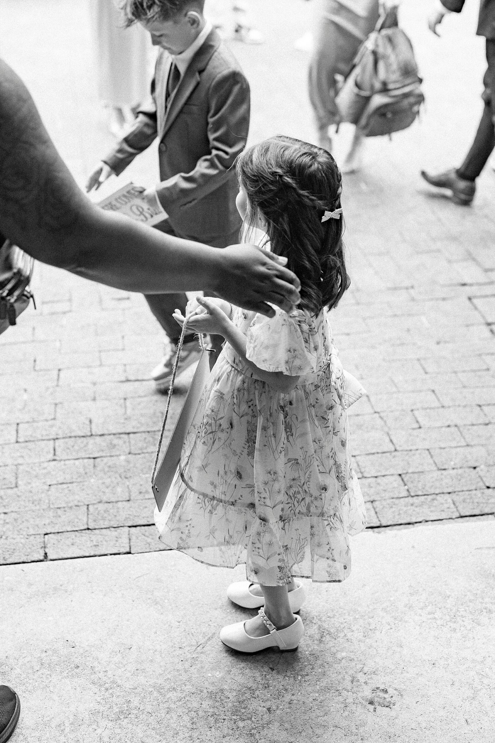 woman pats young girl on shoulder outside church 