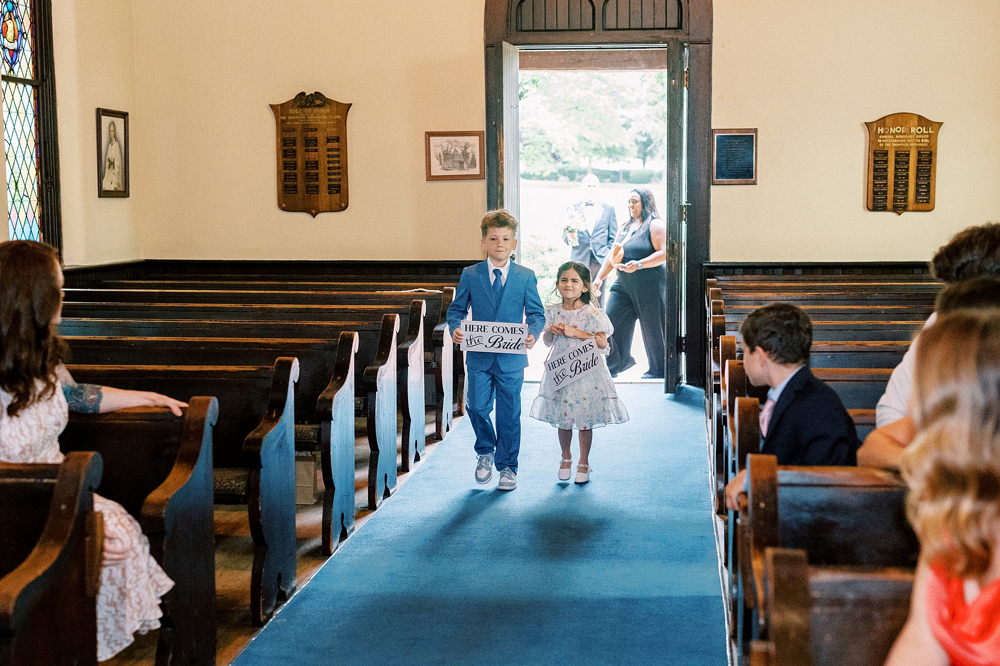 two children walk up aisle during ceremony at St. Mary's Chapel