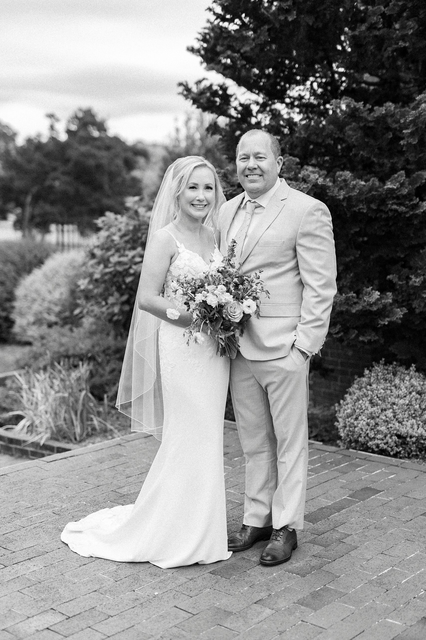 bride and groom stand on brick patio at St. Mary's Chapel
