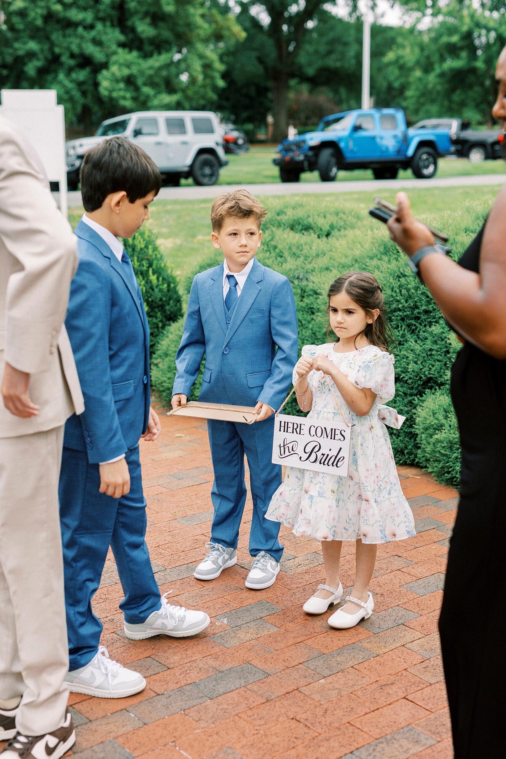 children stand outside St. Mary's Chapel with signs for ceremony 