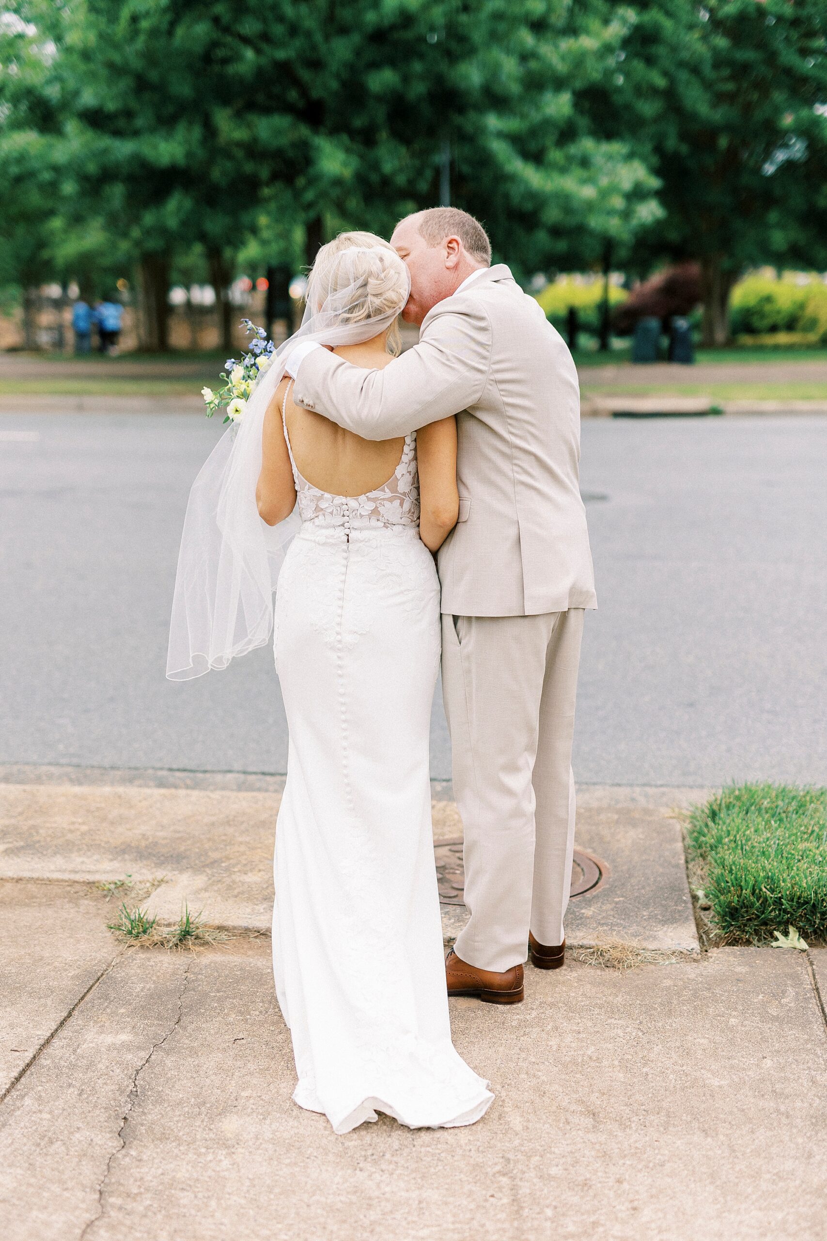 newlyweds hug on brick patio in Uptown Charlotte