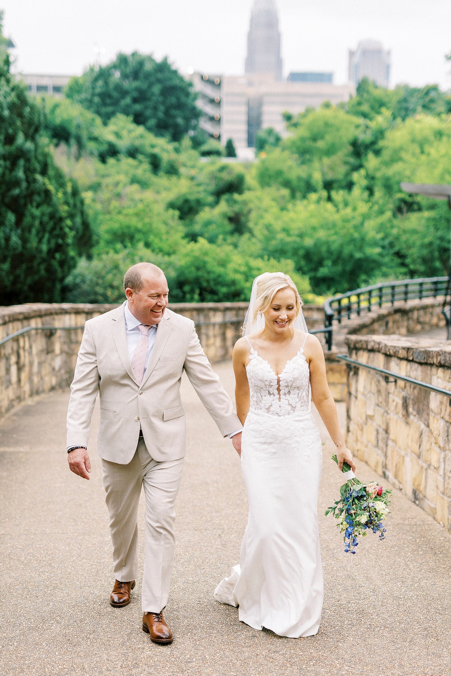 bride and groom hold hands walking through park in Uptown Charlotte