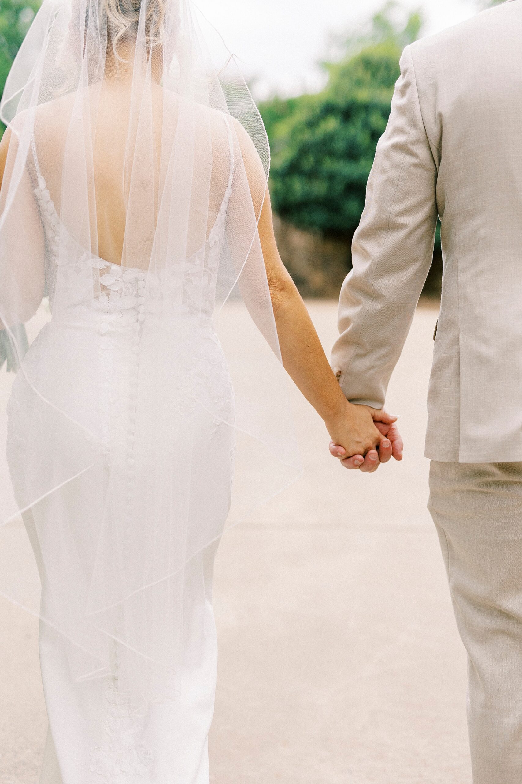 couple holds hands walking through Uptown Charlotte park