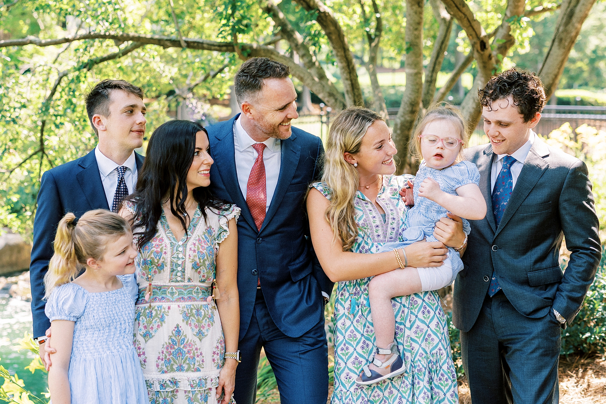 family looks at youngest daughter with Down syndrome during family photos