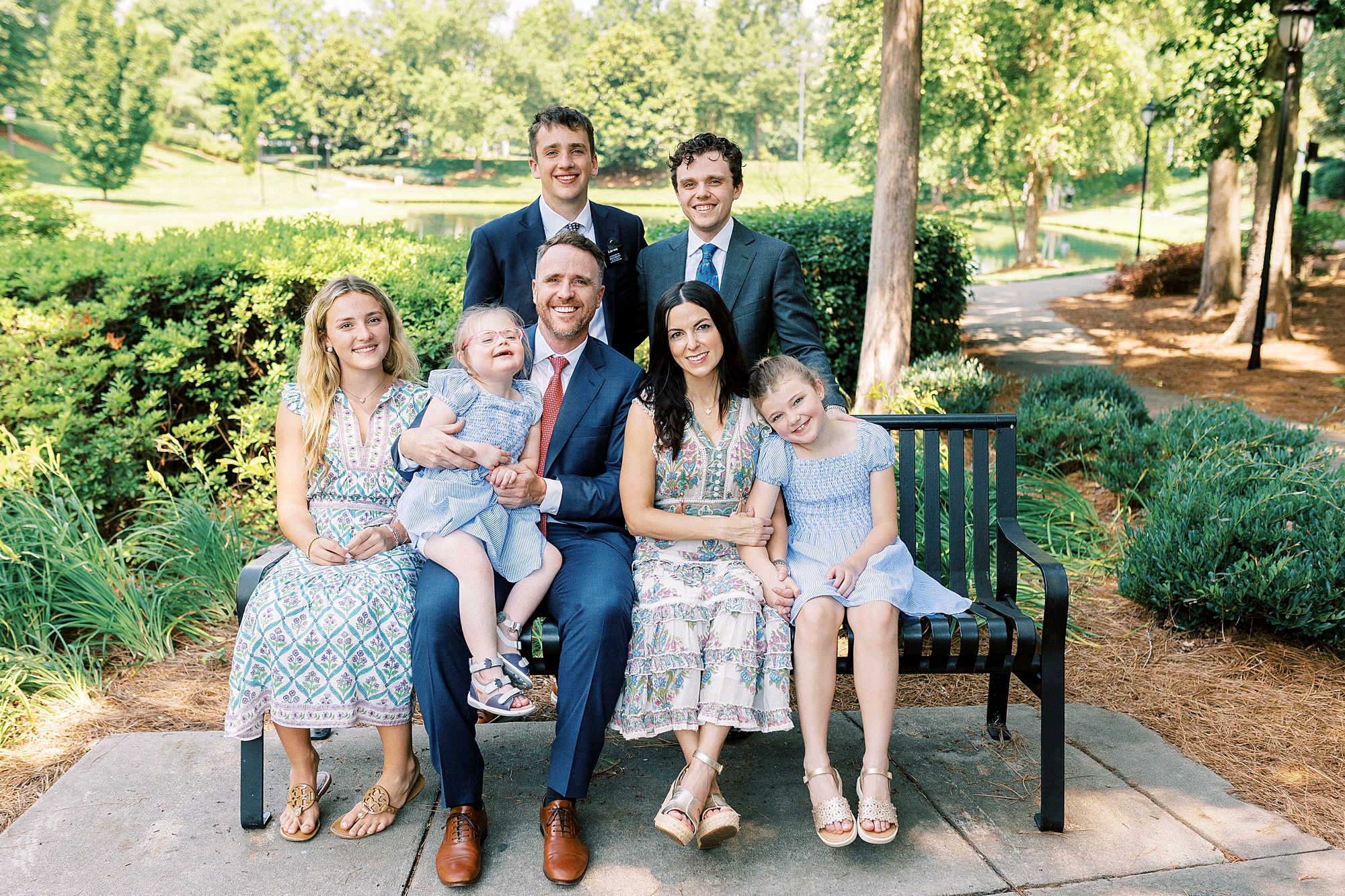 parents sit on bench with 5 children during Cullman Park family photos