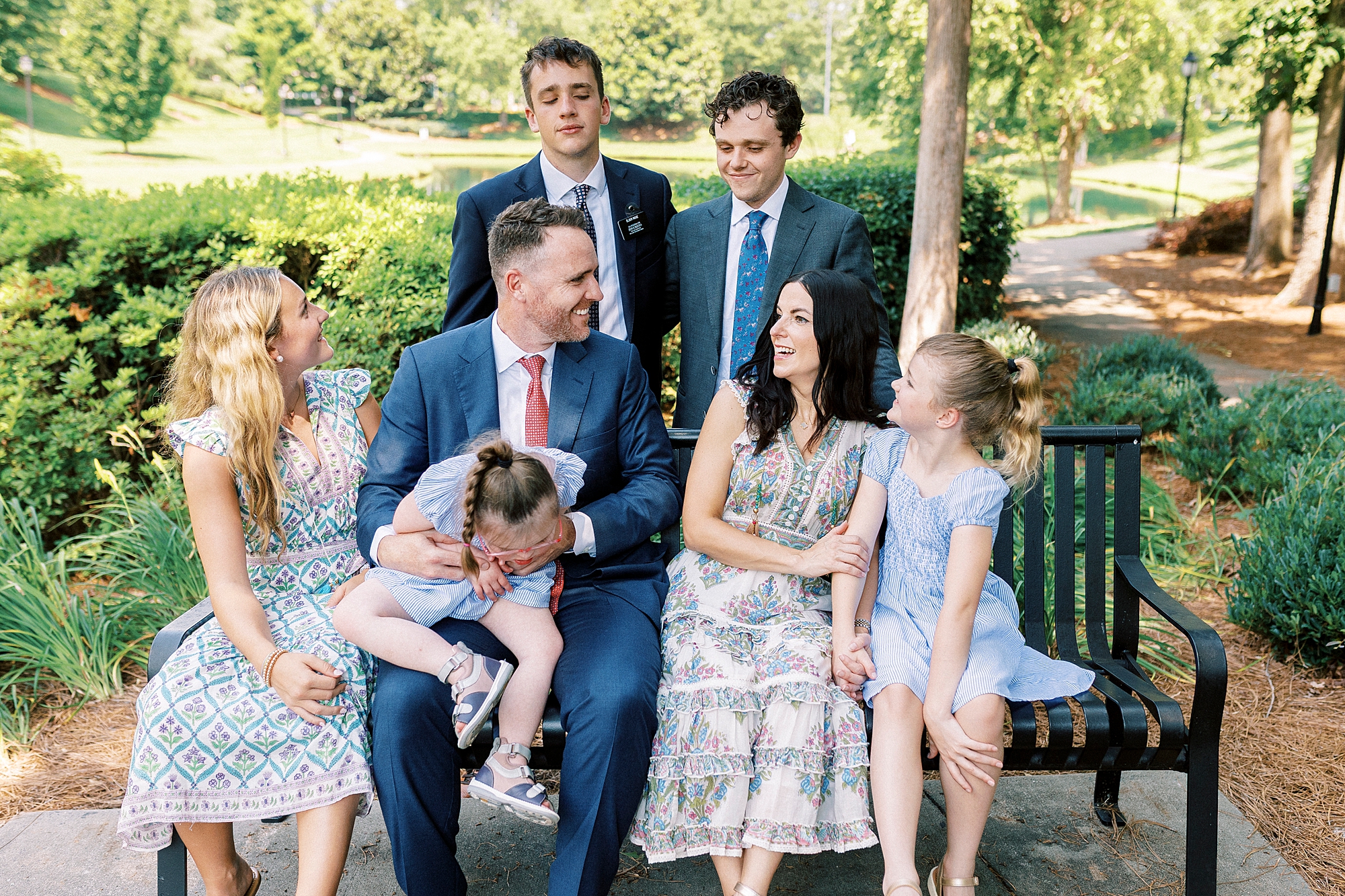 parents and children laugh during family photos in park